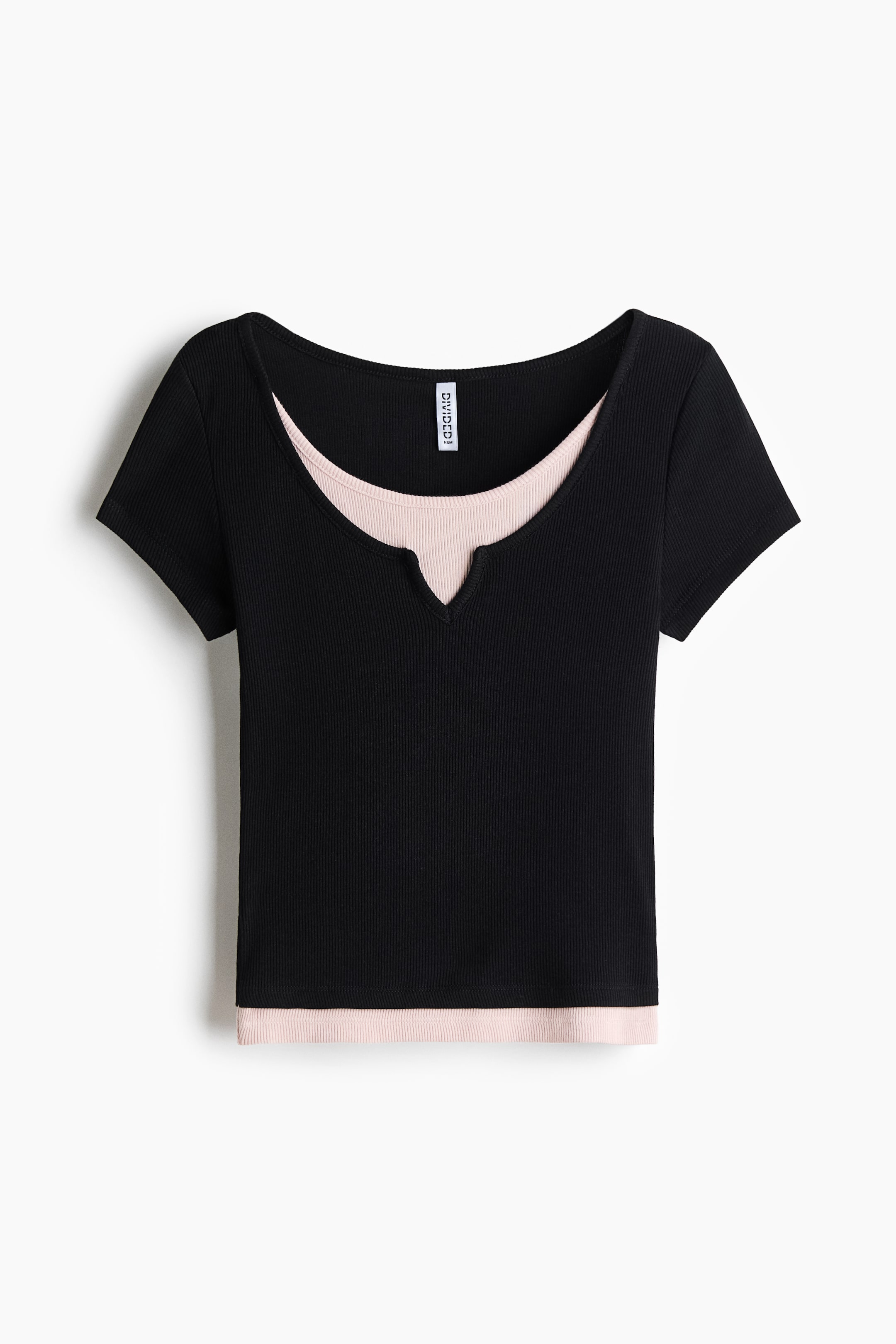 View larger image: A layered top is being displayed from the FRONT. A black ribbed short-sleeved outer top is featuring a scoop neckline with a V-notch cut-out, while it is covering a light pink ribbed inner top that is peeking out from the neckline and bottom hem.