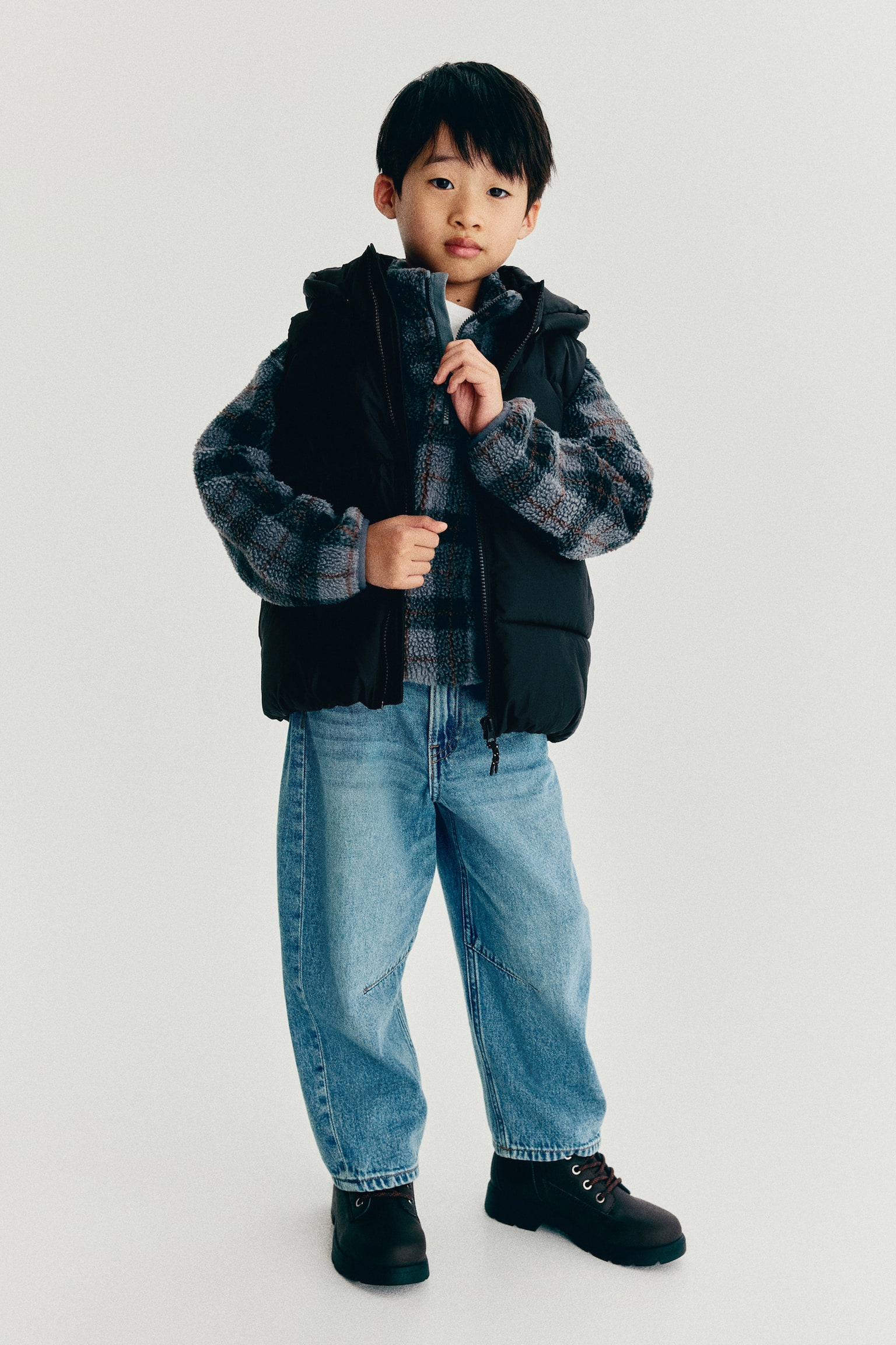 A black hooded puffer vest is presenting its FRONT, featuring a full-length front zipper closure and horizontal quilted sections. - 1