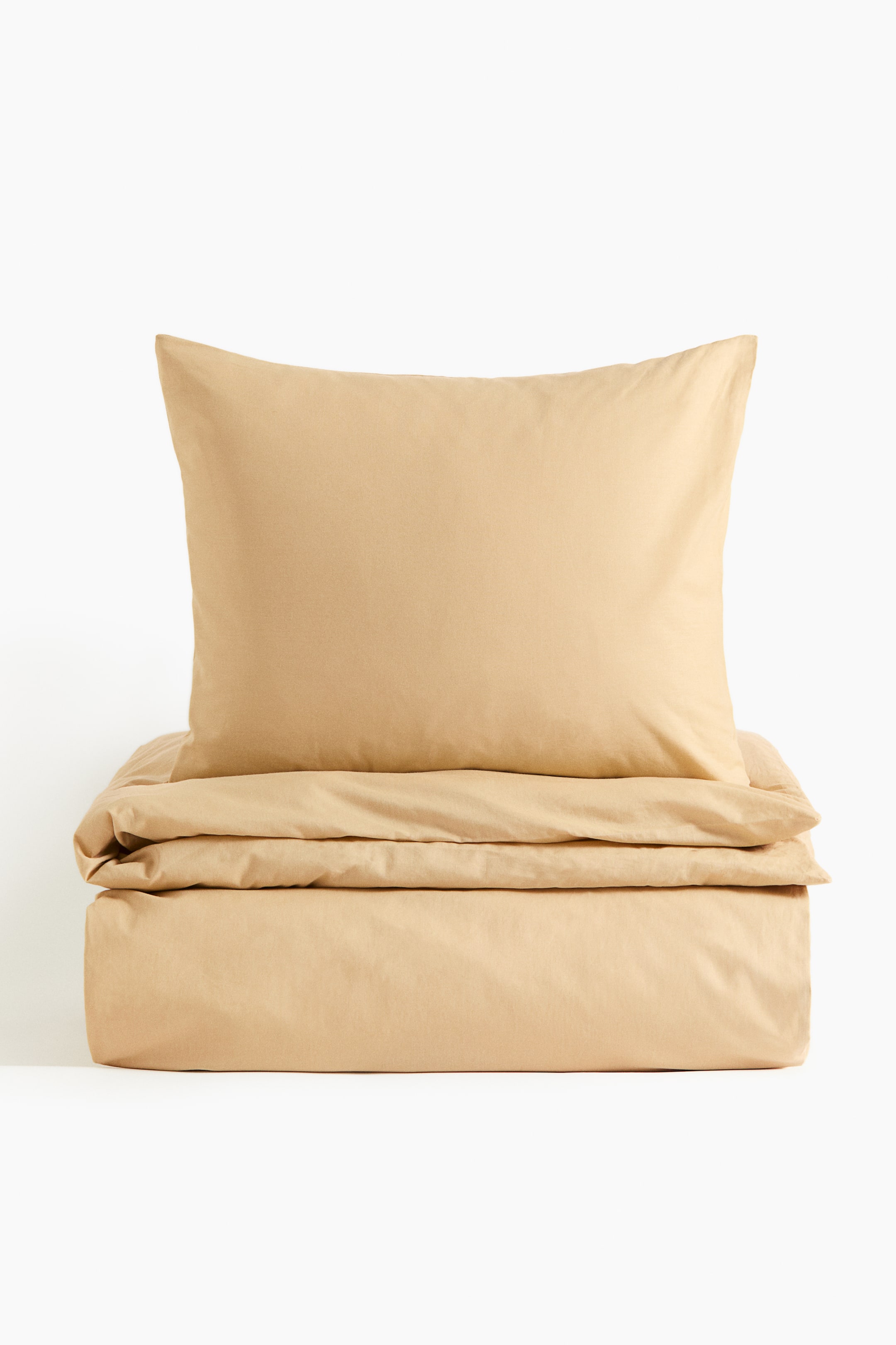 View larger image: A single duvet cover set in beige, fine-thread cotton is being presented, with one pillowcase standing upright and a neatly folded duvet cover resting beneath it, both facing forward.