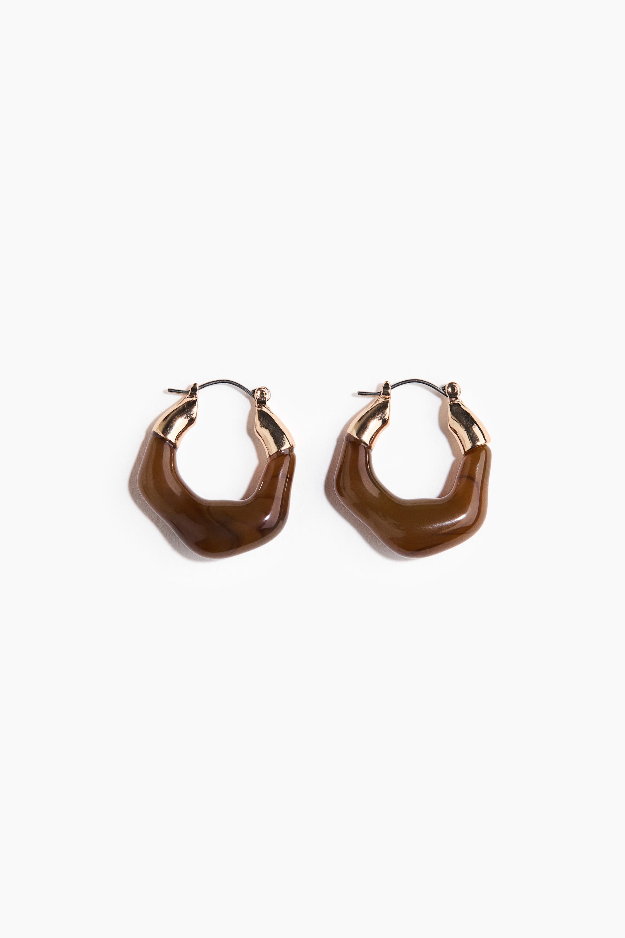 View larger image: A pair of irregular hoop earrings is shown facing front, each featuring a wavy, marbled brown resin hoop that connects to a gold-toned metal cap and a dark ear wire.