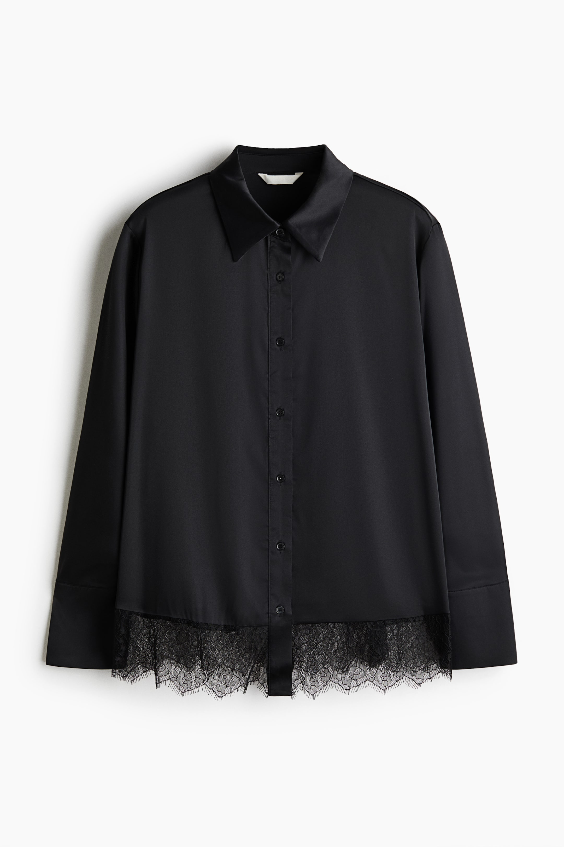 View larger image: A black long-sleeve satin blouse is shown from the front, featuring a pointed collar, a central button placket, and long sleeves with wide cuffs. The straight hemline showcases a delicate, sheer black lace trim with intricate floral patterns.