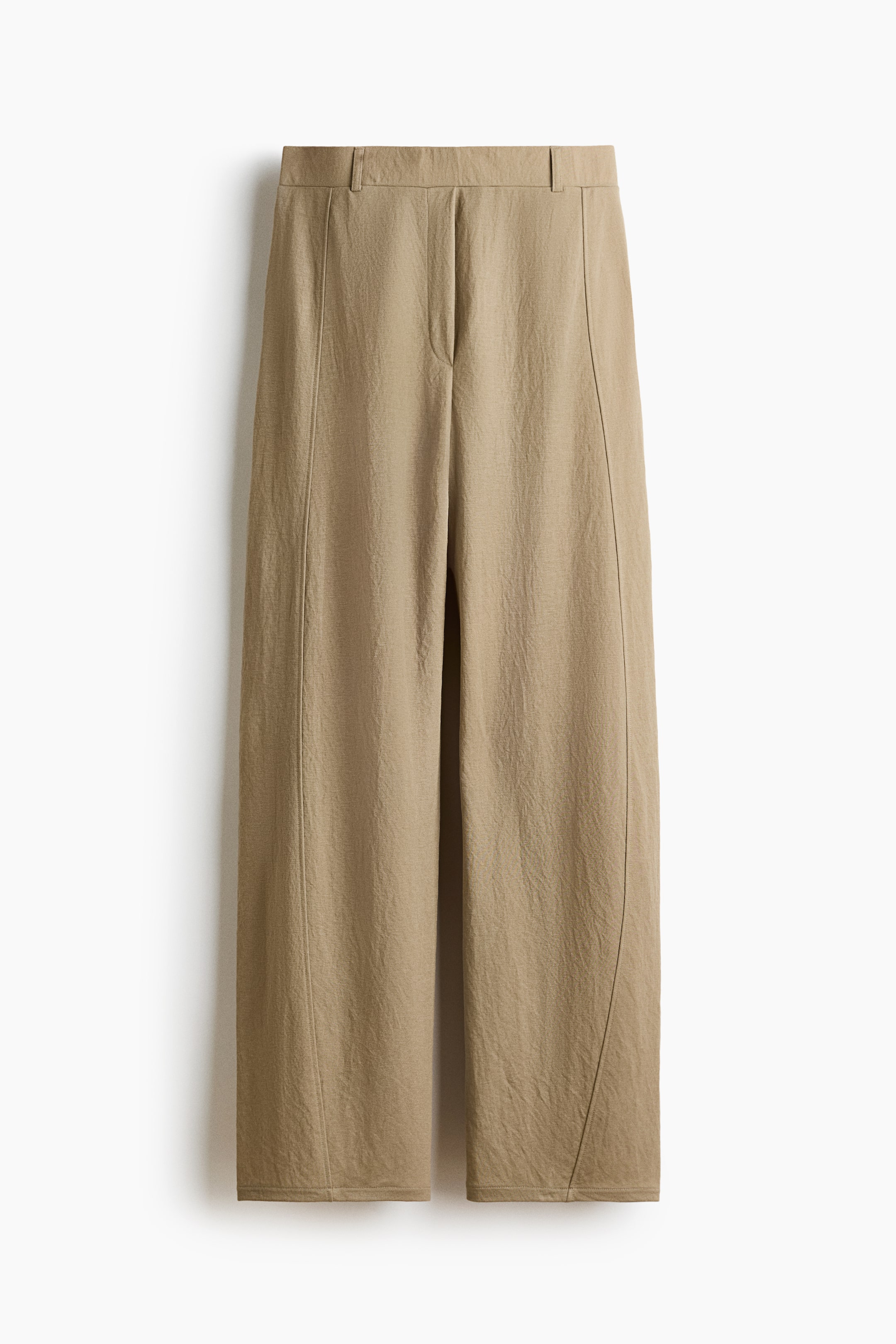 View larger image: Tan wide-leg trousers feature a flat waistband with belt loops and a concealed front closure. Vertical seam detailing runs down the front of each leg, curving subtly towards the hem, on the subtly textured fabric.