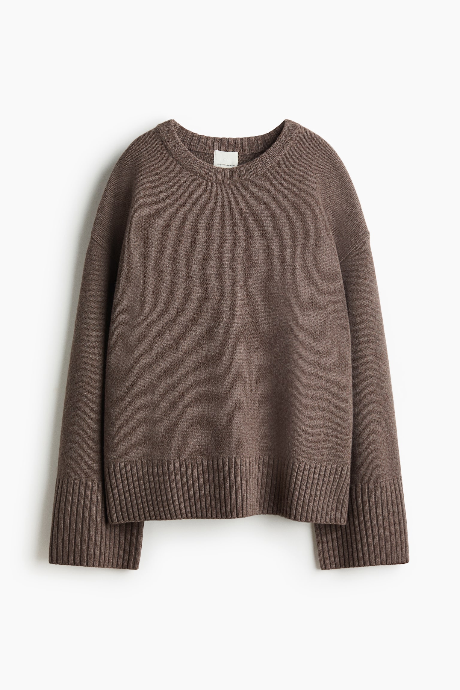 A brown oversized jumper is presented from the front, showcasing a soft knit and dropped shoulders. It features extra-long sleeves with wide ribbed cuffs, along with a ribbed round neckline and hem. - 1