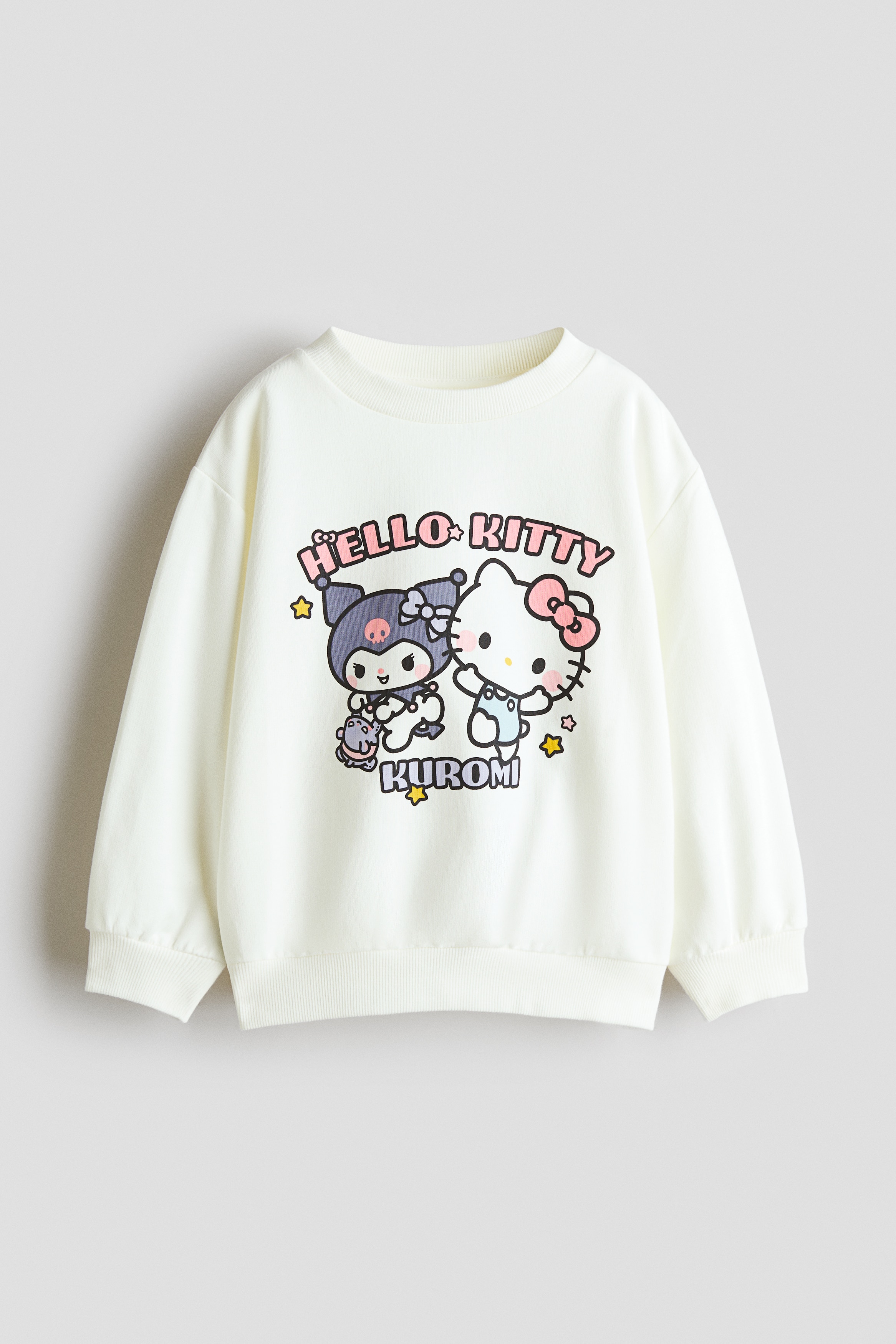 ã¯ãªã¼ã è²ã®é·è¢ã»ã¼ã¿ã¼ãã¢ãã«ãçç¨ãã¦ãããããã³ãã«ã¯Hello Kittyã¨Kuromiã®ã«ã©ãã«ãªããªã³ãã°ã©ãã£ãã¯ããããããã¦ãã¾ããã»ã¼ã¿ã¼ã¯ããªã仿§ã®ã©ã¦ã³ãããã¯ãããããã·ã§ã«ãã¼ãå¹
åºã®ãªã裾ãç¹å¾´ã§ããã«ã¼ããã ã¸ã¼ã³ãºã¨åããã¦ãã¾ãã