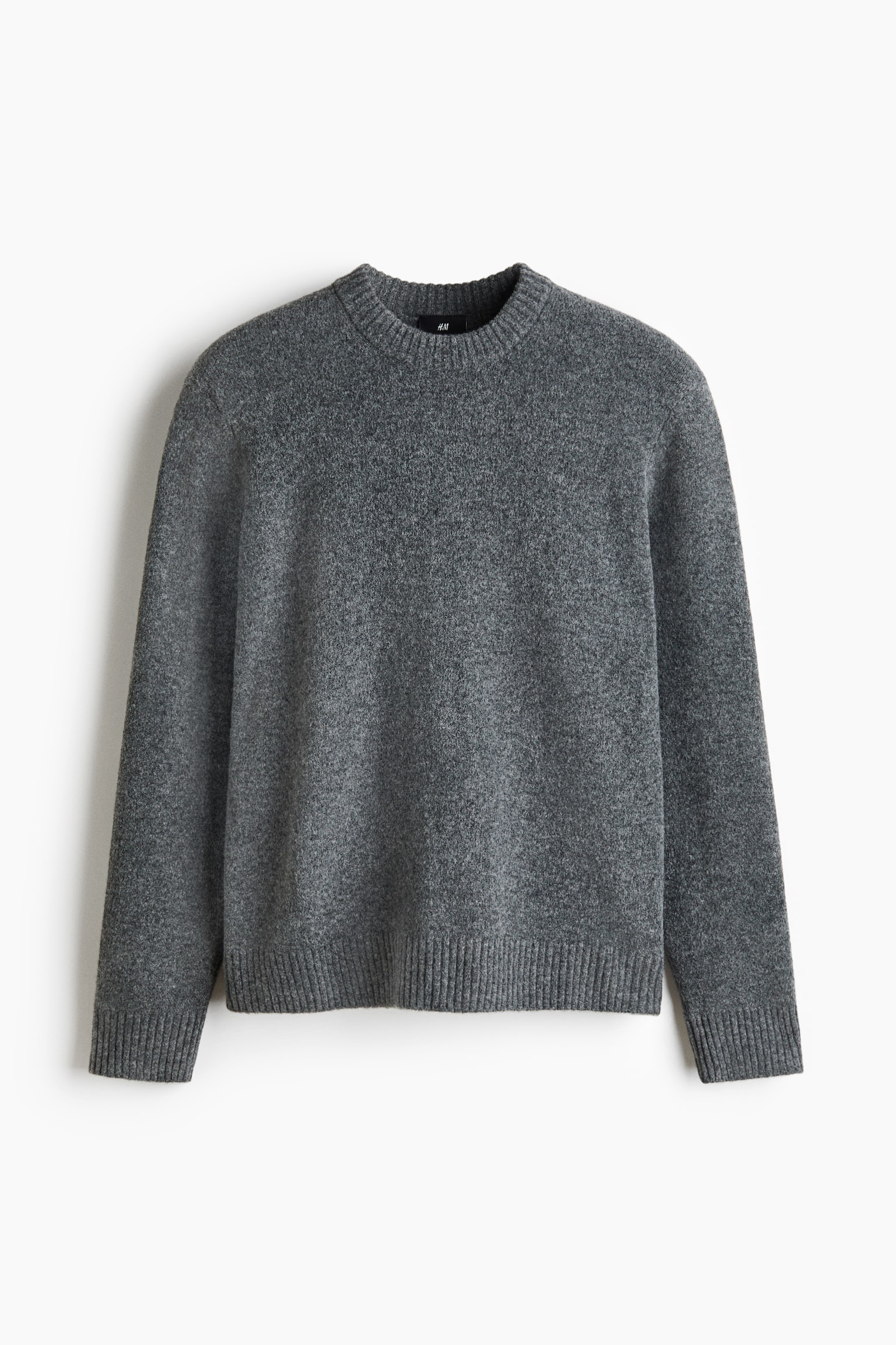 A heathered dark grey crew neck sweater is lying flat, facing forward, featuring long sleeves with ribbed cuffs and a ribbed hem.