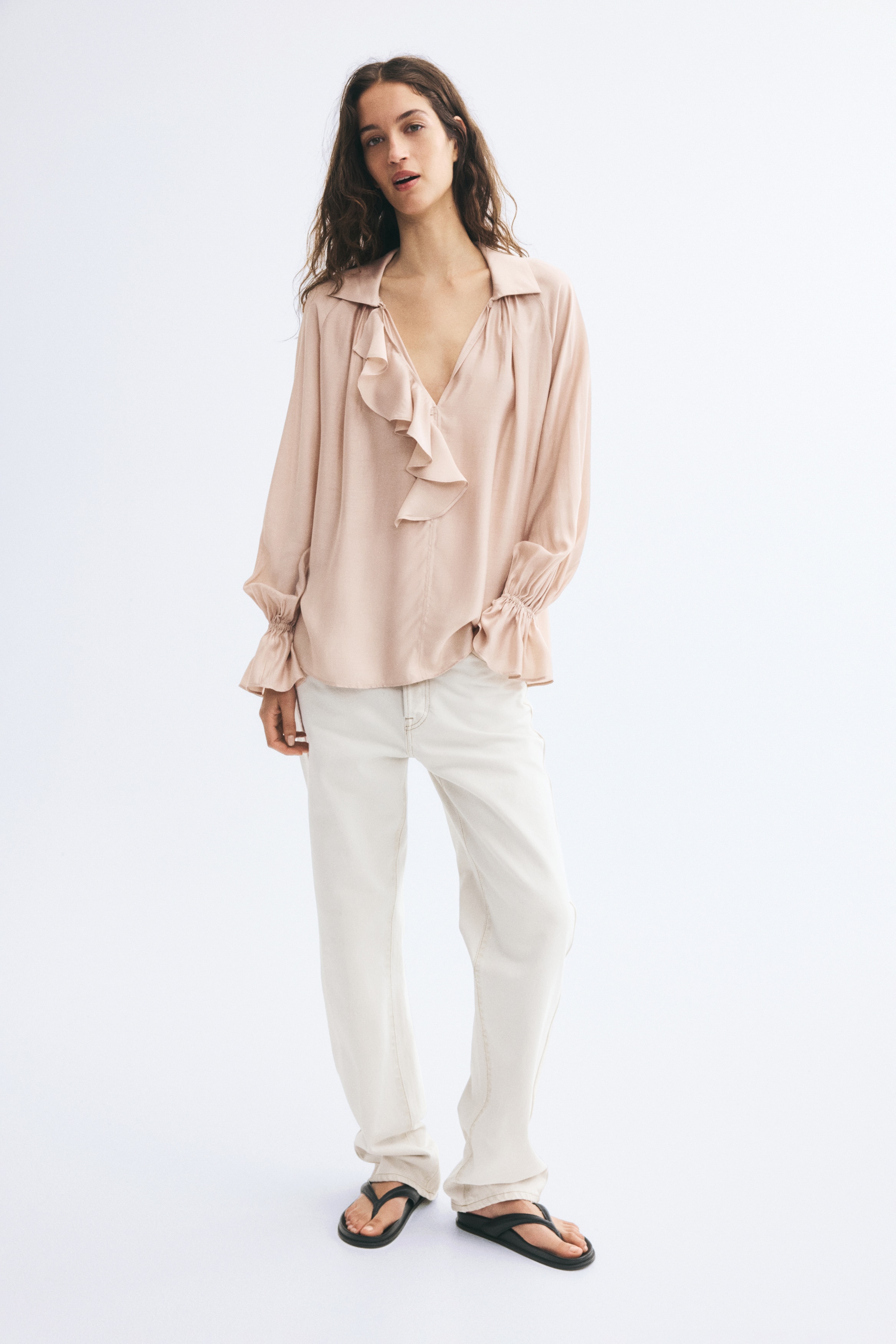 Má»t chiáº¿c Ã¡o blouse mÃ u há»ng pháº¥n bá»¥i, chá»¥p chÃ­nh diá»n, ná»i báº­t vá»i cá» báº» nhá»n, hÃ ng cÃºc xáº¿p bÃ¨o rá»§ dá»c giá»¯a thÃ¢n vÃ  phom dÃ¡ng buÃ´ng rá»§, rá»ng thoáº£i mÃ¡i. Thiáº¿t káº¿ cÃ³ tay dÃ i phá»ng rá»ng, bo chun á» cá» tay vÃ  xÃ²e bÃ¨o á» pháº§n cá» tay.