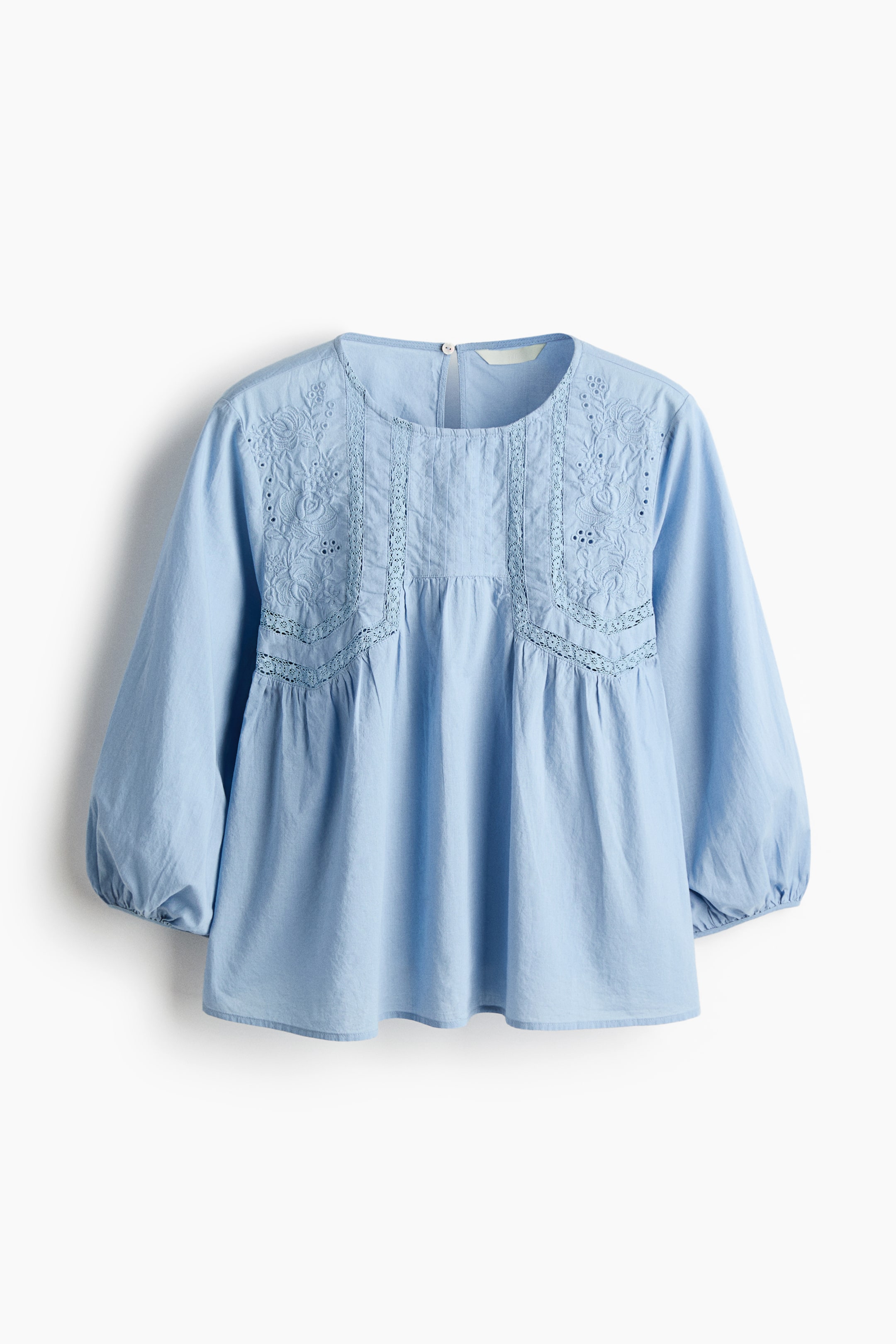 View larger image: A loose-fit blouse in a cotton weave is facing FRONT, featuring a round neckline, and a keyhole opening and button are showing at the back. The front is detailing a gathered yoke with broderie anglaise, lace insets, and pintucks, while 3/4-length balloon sleeves are completing the design, featuring narrow elastication at the cuffs.