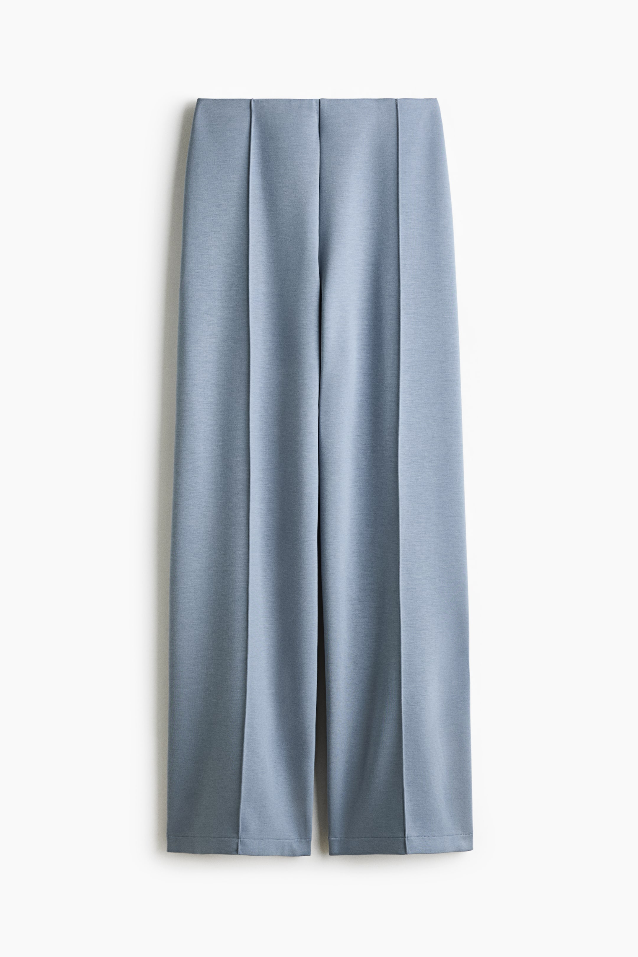Agrandir l'image: Un pantalon bleu clair en tissu scuba lisse est présenté de face, avec une ceinture épurée et des jambes droites ornées de plis verticaux cousus au centre de chaque jambe.