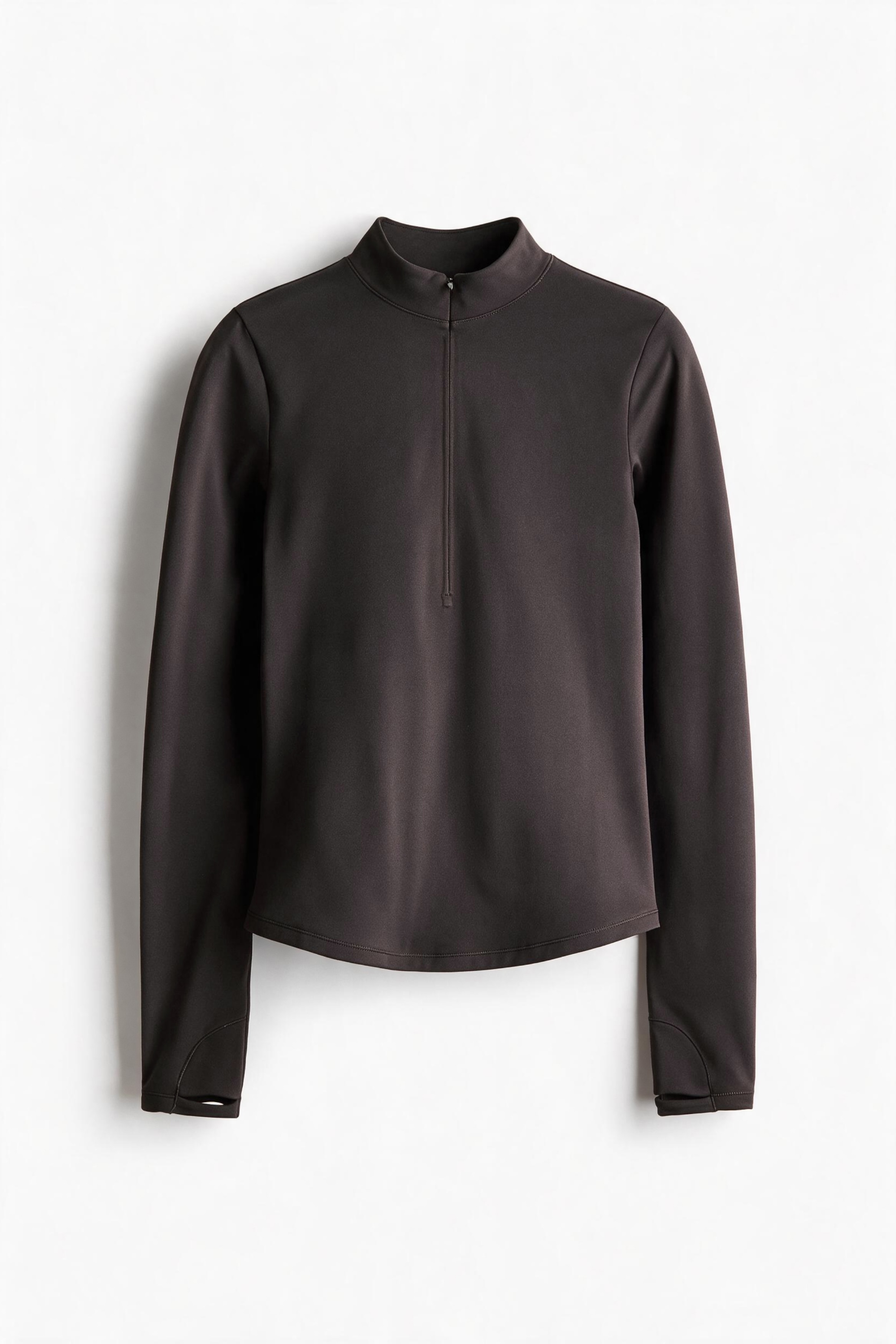 A dark brown, long-sleeved activewear top is being worn by the model. The top features a fitted silhouette, a mock-neck collar, and a central front zipper closure.