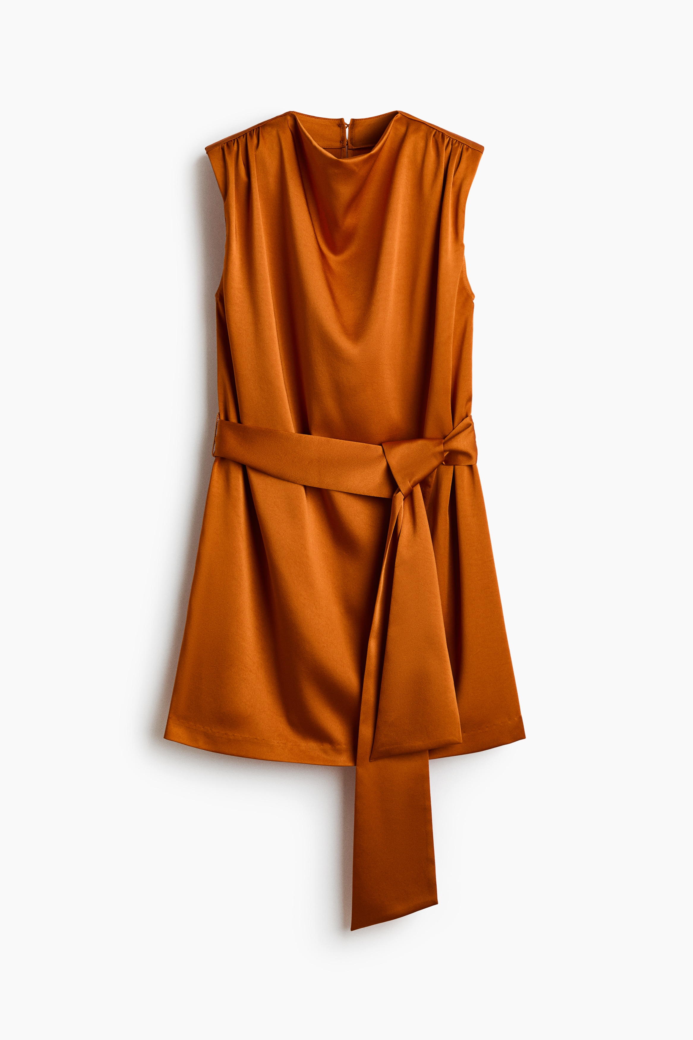 Un mannequin porte une courte robe en satin sans manches de couleur orange dorÃ©, vue de face pour mettre en valeur son col bÃ©nitier drapÃ© et ses Ã©paules rembourrÃ©es avec coutures froncÃ©es. La robe est cintrÃ©e Ã  la taille par une large ceinture assortie Ã  nouer, qui retombe sur le devant.