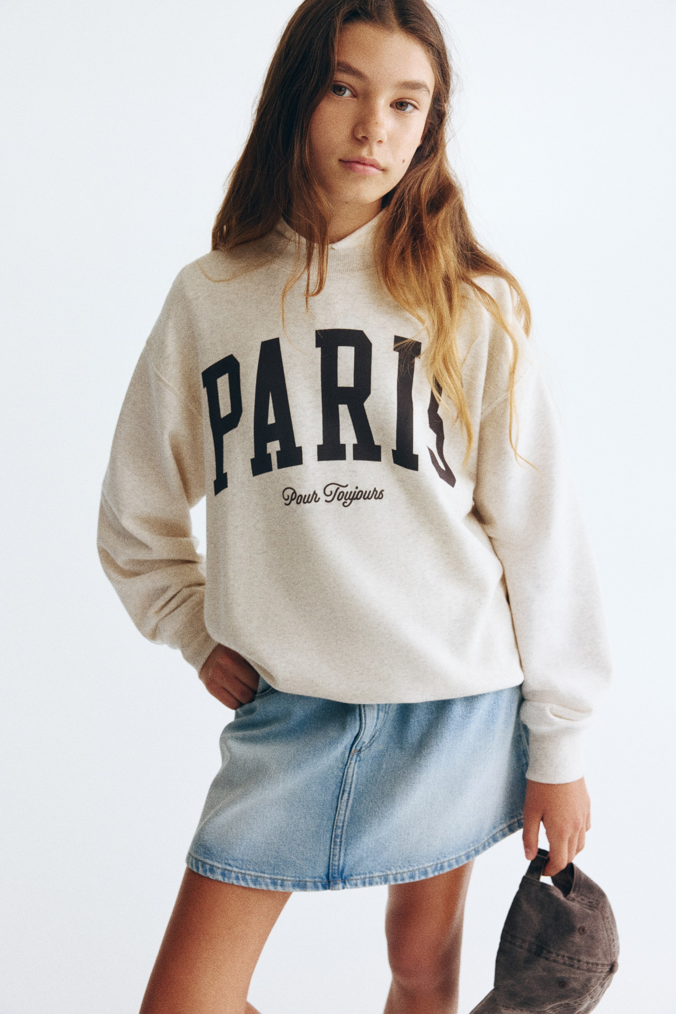 View larger image: A loose-fit top in light beige lightweight sweatshirt fabric is displayed in the front. It features a "PARIS Pour Toujours" print motif, a round rib-trimmed neckline, dropped shoulders, long sleeves, and ribbing at the cuffs and hem.