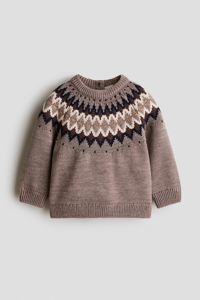 A front-facing knit jumper in soft taupe is displaying a decorative jacquard-patterned yoke in navy, white, and brown around its round, ribbed neckline. It is featuring long raglan sleeves, ribbed cuffs, a ribbed hem, and a small button opening at the back collar. - 1