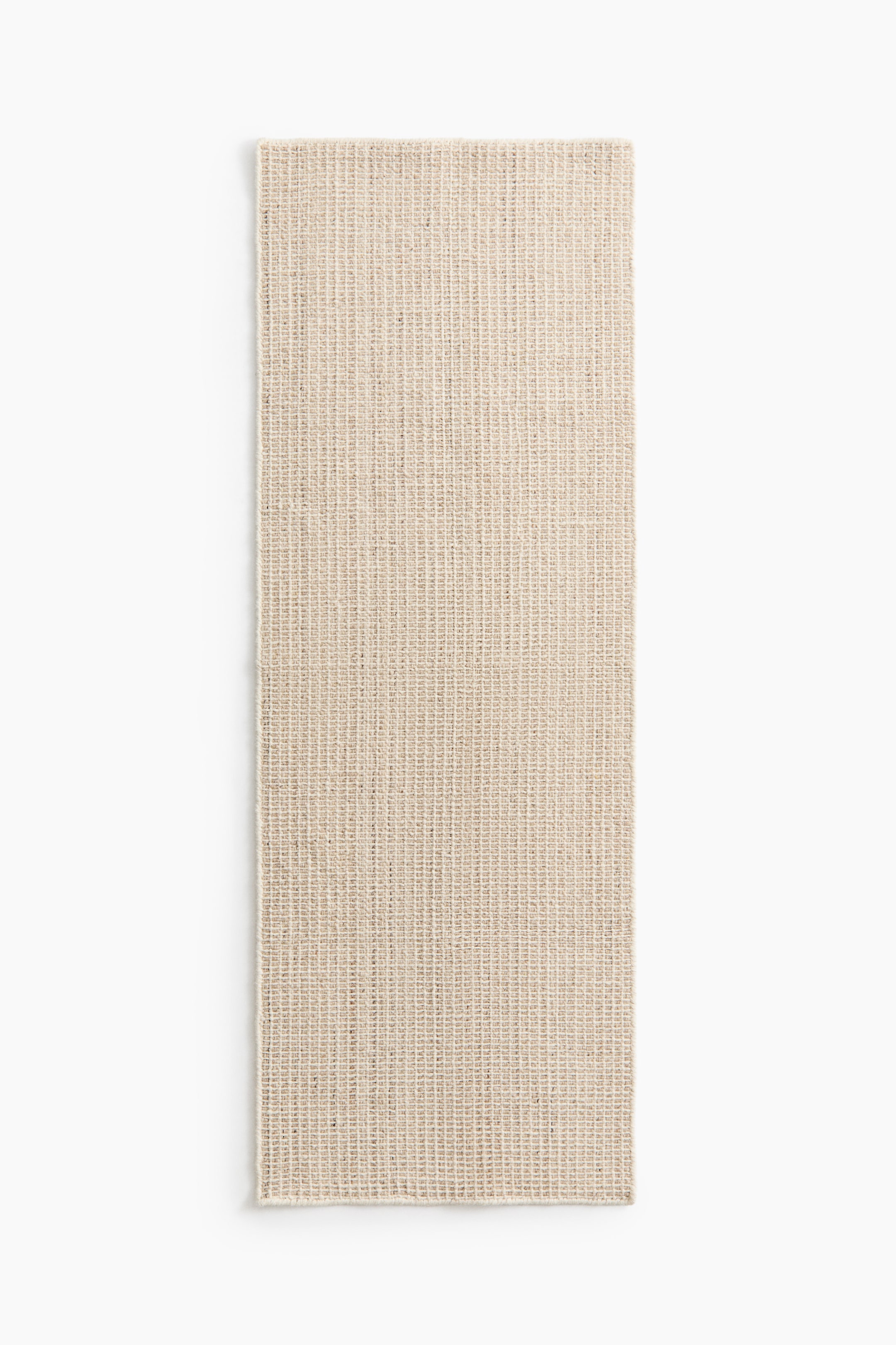 Ampliar la imagen: Una pieza rectangular de textil tejido en color beige claro presenta una textura gruesa, similar a una cuadrícula, con bordes ligeramente deshilachados, colocada en posición plana.