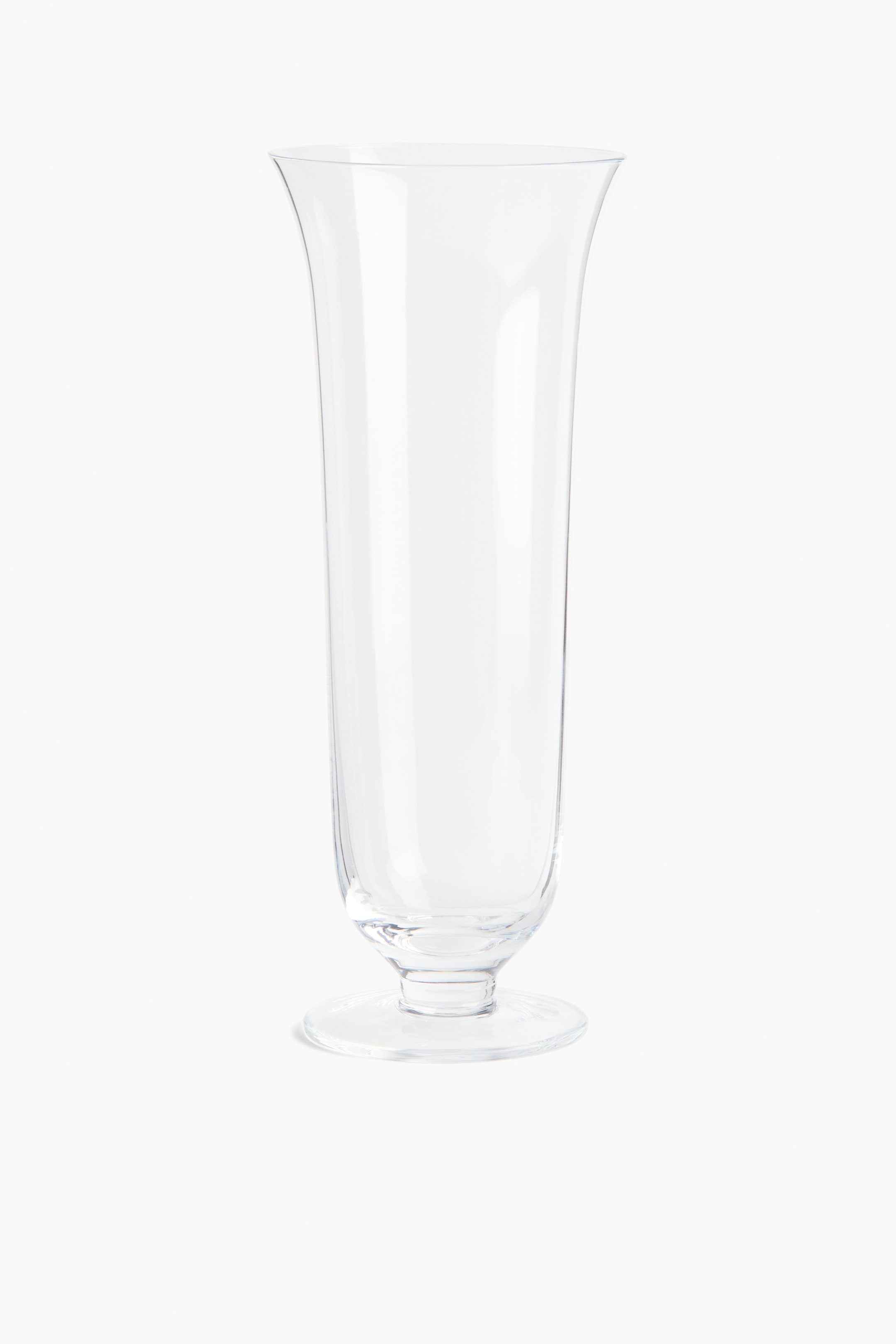 이미지 확대 보기: 투명 유리 꽃병은 위쪽 가장자리에서 바깥쪽으로 퍼지는 약간 좁아진 긴 몸체와 원형 받침대에 놓인 디자인이 특징입니다.