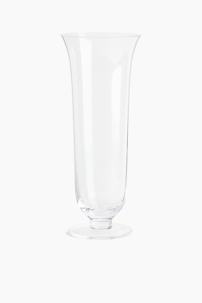 A clear glass vase featuring a tall, slightly tapered body that flares outward at the top rim and rests on a circular footed base. - 1