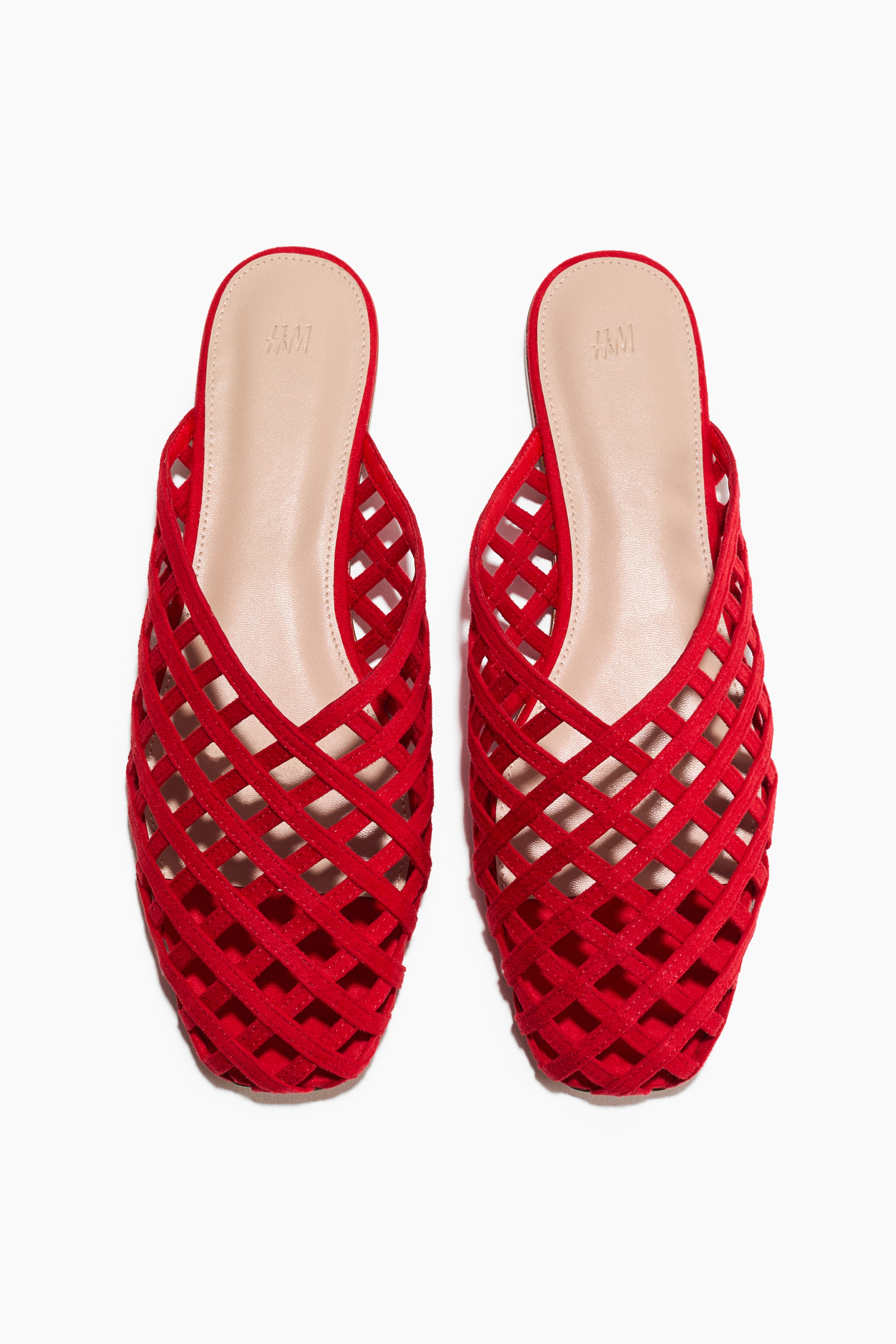 View larger image: "A pair of red mules is presenting with narrow, interwoven straps forming a lattice pattern across the foot, square toes, and a visible light beige insole."