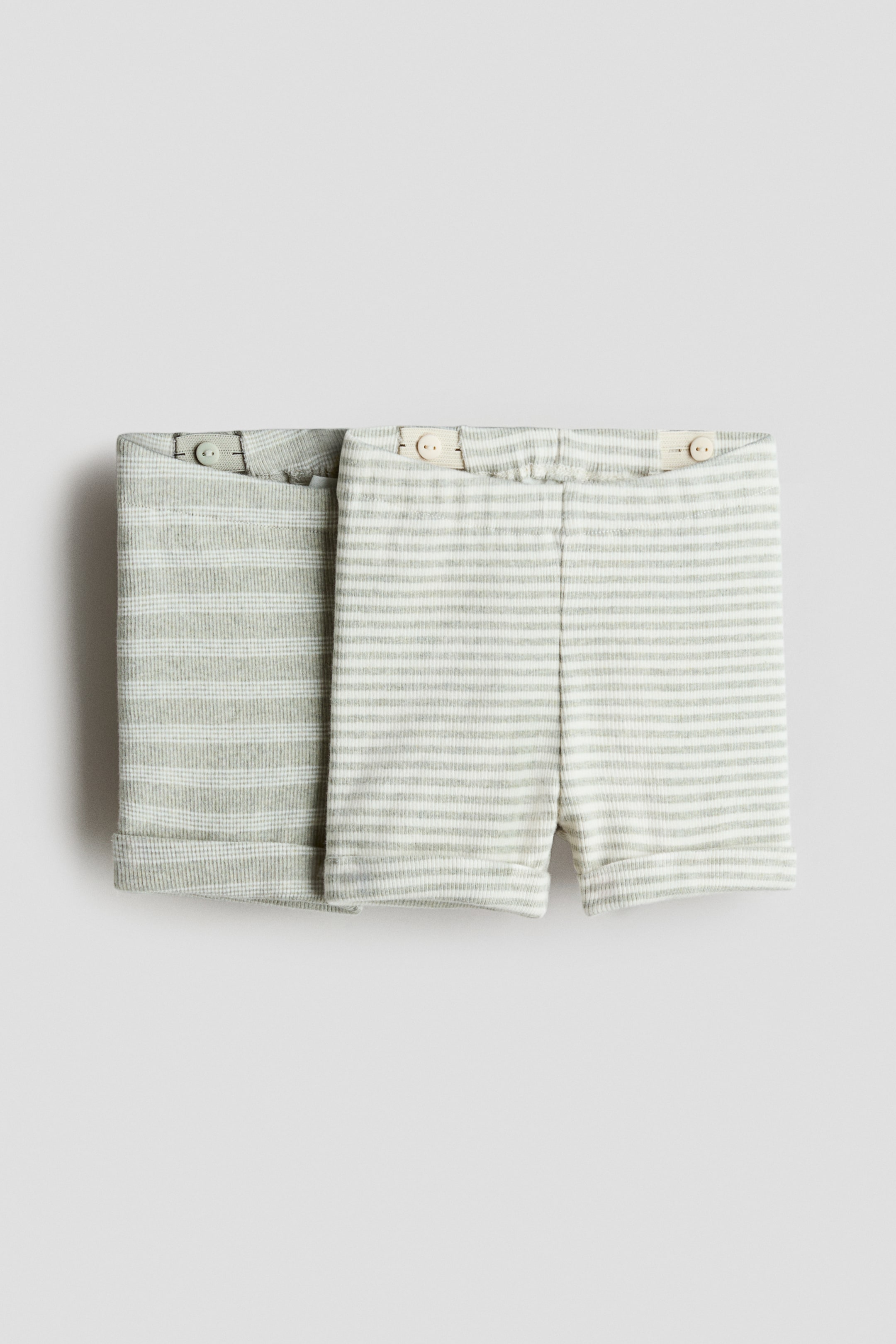 Agrandir l'image: Un lot de 2 shorts en jersey de coton est présenté, avec des motifs à rayures vert clair et blanc, des ceintures élastiques avec boutons internes réglables, et des ourlets roulés.