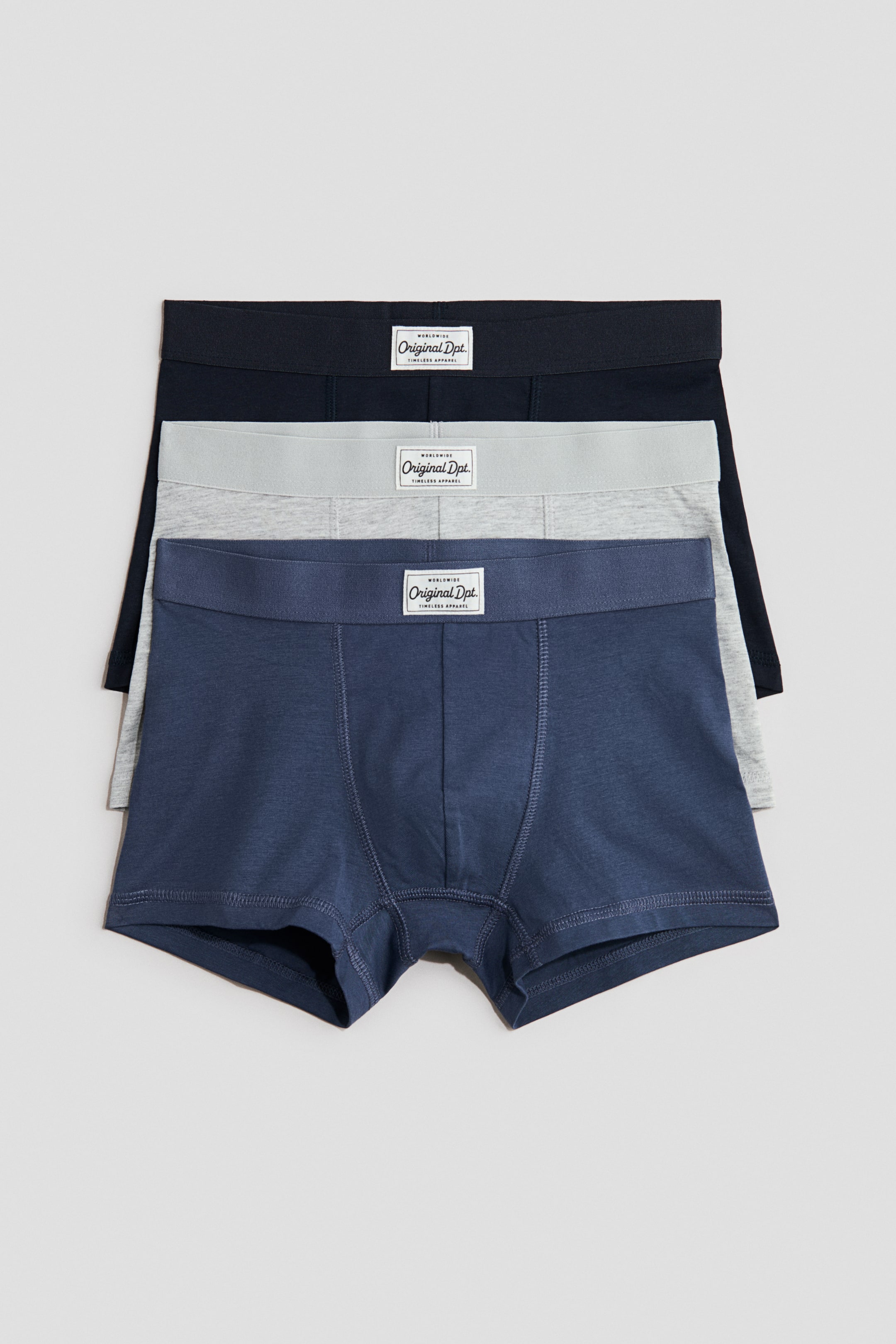 View larger image: Tatlong men's boxer briefs ang nakapatong, ipinapakita ang isang madilim na asul, isang magaan na kulay abo, at isang navy na pares. Bawat boxer brief ay may malapad na elastic na waistband na may puting woven na label sa harap na gitna at isang nakikitang front fly panel.