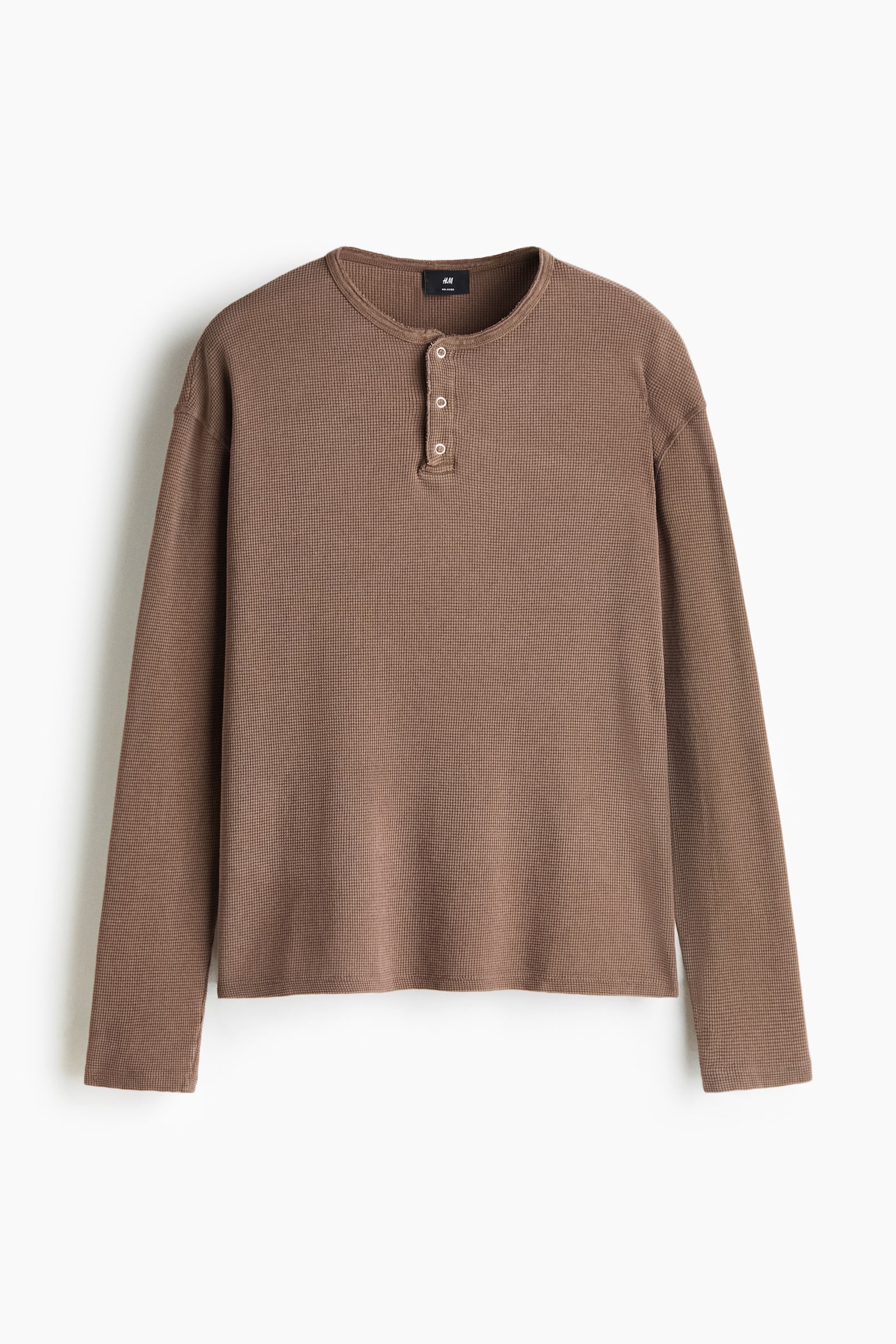 HnÄdý dlouhý rukáv Henley top z žebrovaného bavlnÄného jersey je zachycen z ÄelnÃho úhlu a má uvolnÄný stÅih se spuÅ¡tÄnými rameny. Top zobrazuje kulatý výstÅih s tÅÃknoflÃkovou légou, jednoduché rovné manžety a rovnÄ stÅižený lem.