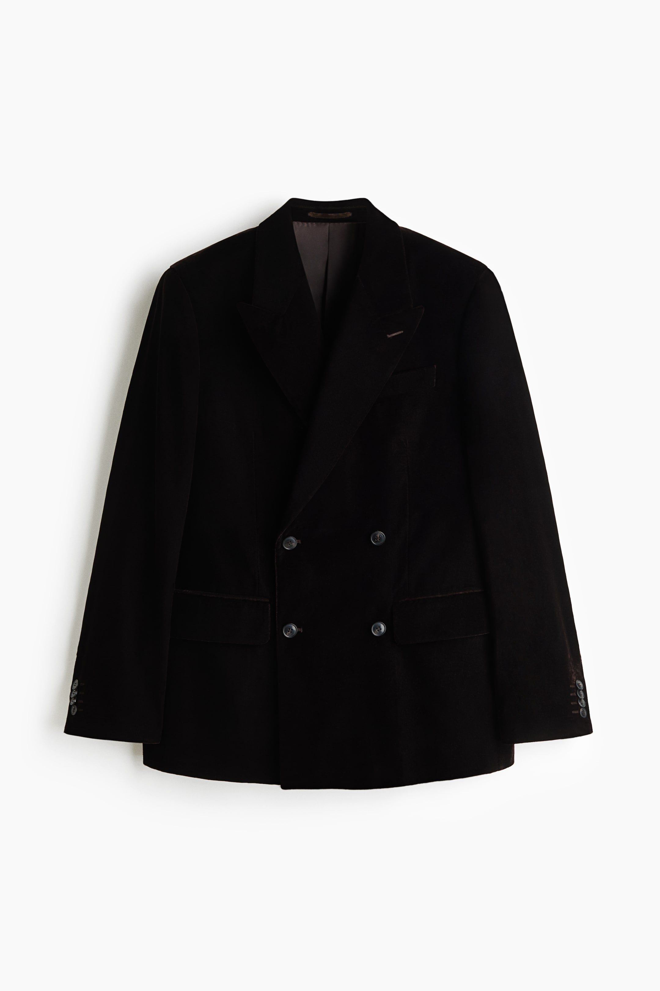 View larger image: A black velvet double-breasted blazer is shown facing forward, featuring prominent peak lapels, a four-button front closure, and two side flap pockets. The blazer has structured shoulders, a left chest welt pocket, and long sleeves with buttoned cuffs.