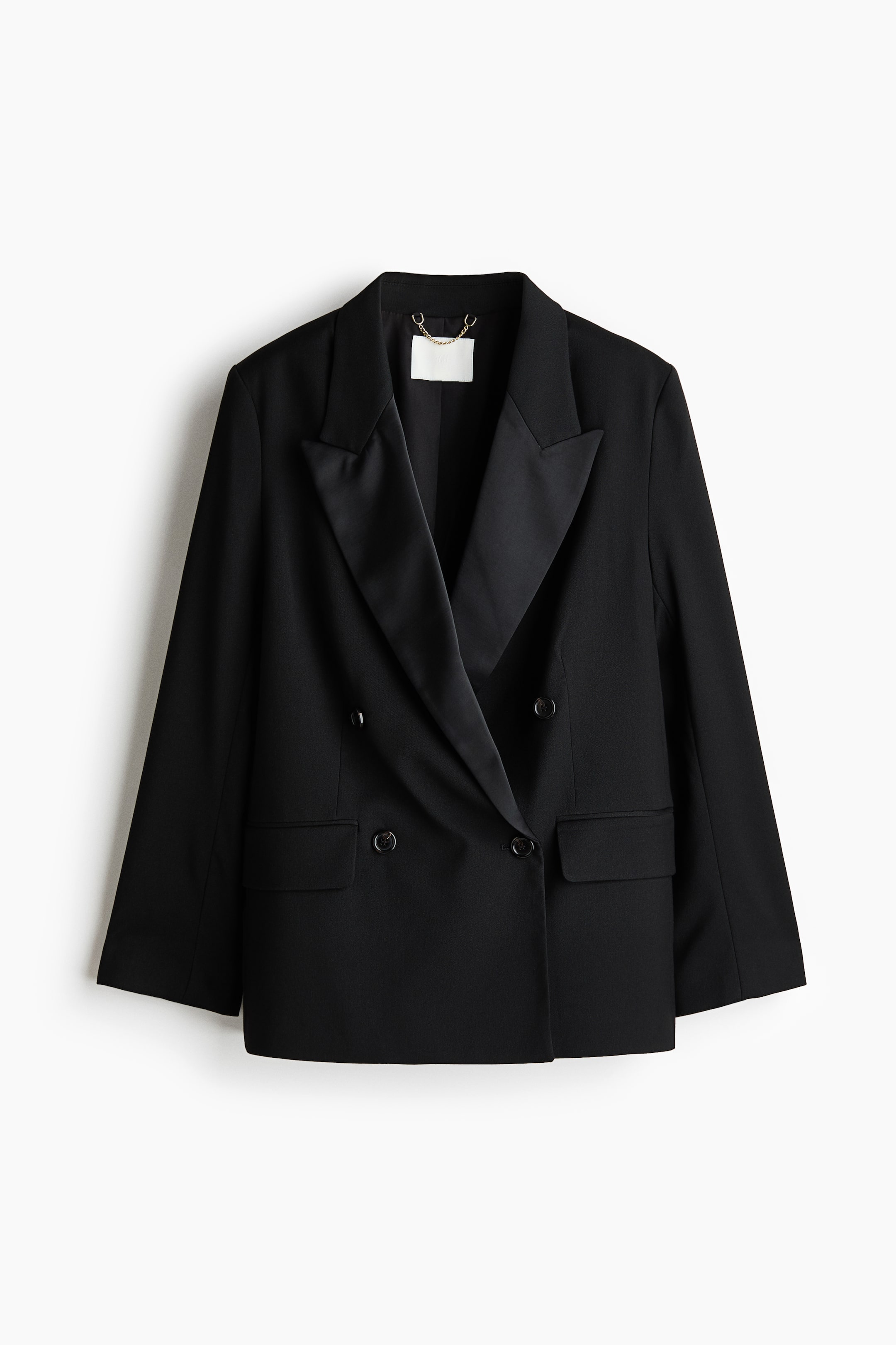 View larger image: A black double-breasted blazer is hanging facing forward, featuring wide, satin-finished peak lapels and a structured woven body. It showcases a double-breasted button closure and two front welt pockets with flaps.