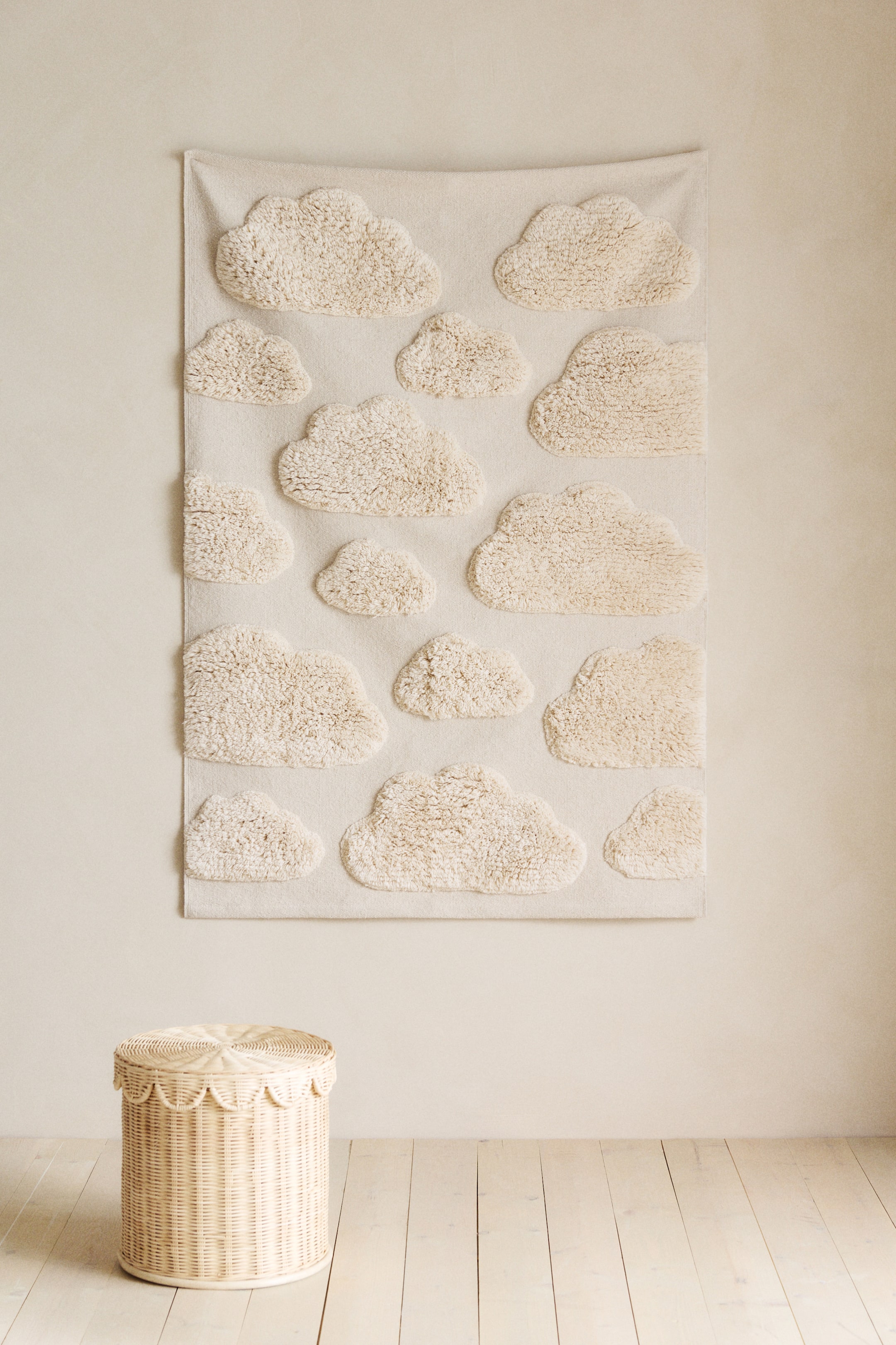 View larger image: A cream-coloured textile wall hanging showcases a pattern of multiple raised, shaggy cloud shapes.