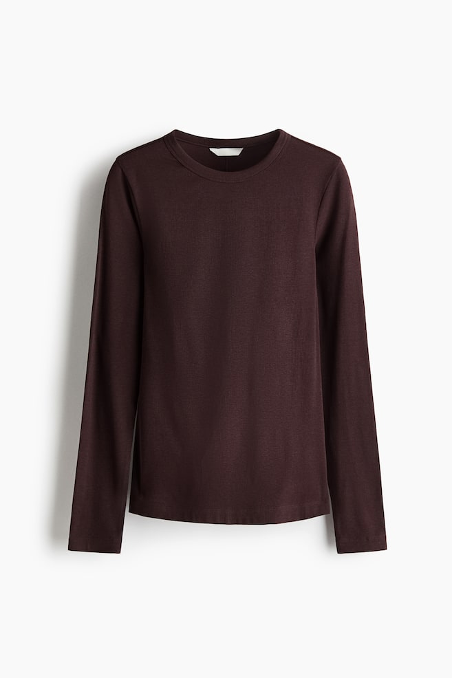 A dark burgundy, long-sleeved top is shown from the front, featuring a round neckline and a fine ribbed jersey texture. The fitted garment is hanging straight, showcasing its long sleeves and clean, straight hem. - 1