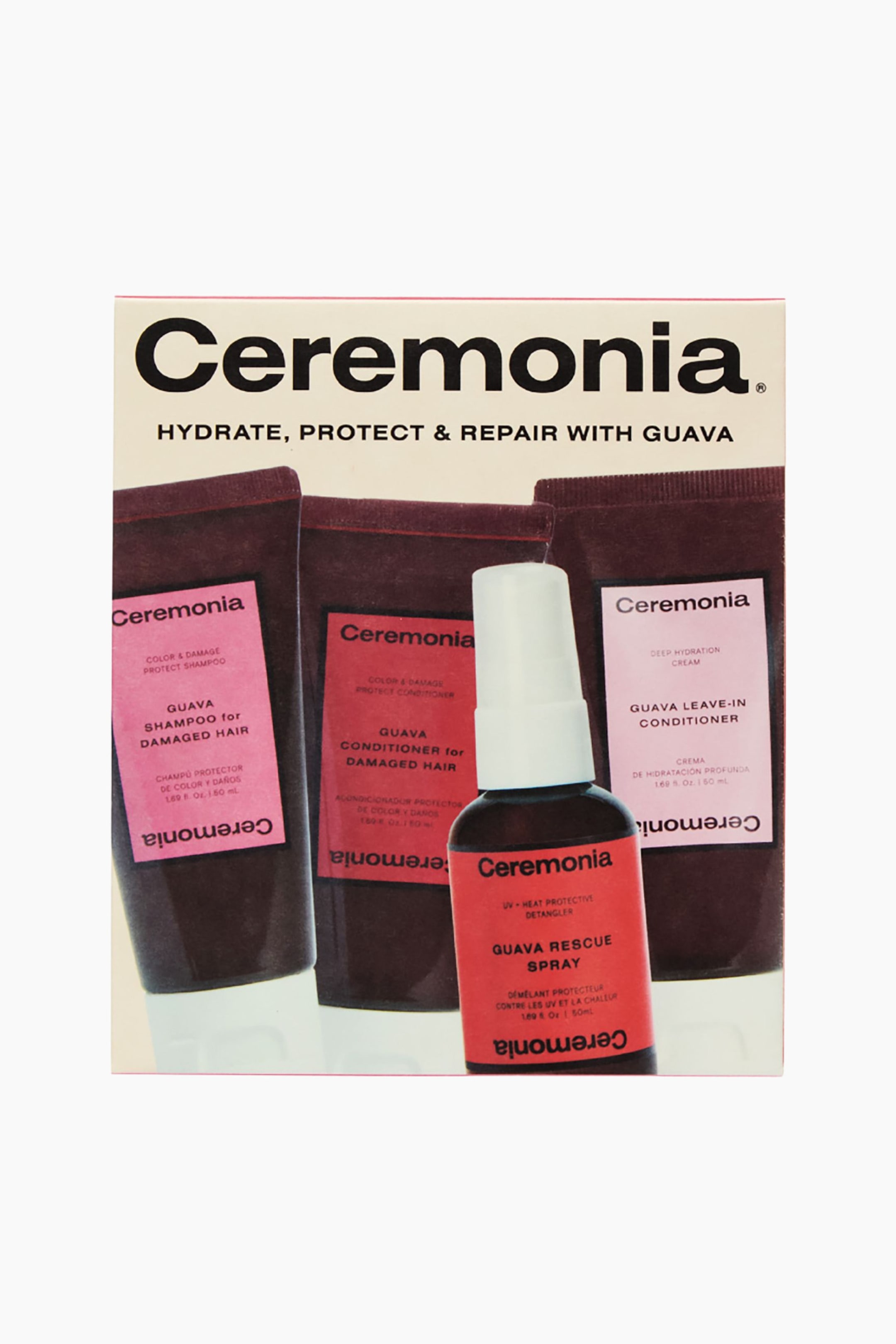 Vis større bilde: Ceremonia hårpleiesett presenteres i en krem- og svart rektangulær eske, med teksten 'Hydrate, Protect & Repair with Guava'. Inni esken står tre mørkerødbrune klemmetuber oppreist, merket Guava Shampoo for Skadet Hår, Guava Balsam for Skadet Hår, og Guava Leave-In Balsam. En mørkerødbrun sprayflaske med hvit pumpehette, merket Guava Rescue Spray, står foran, delvis skjulende leave-in balsam tuben.