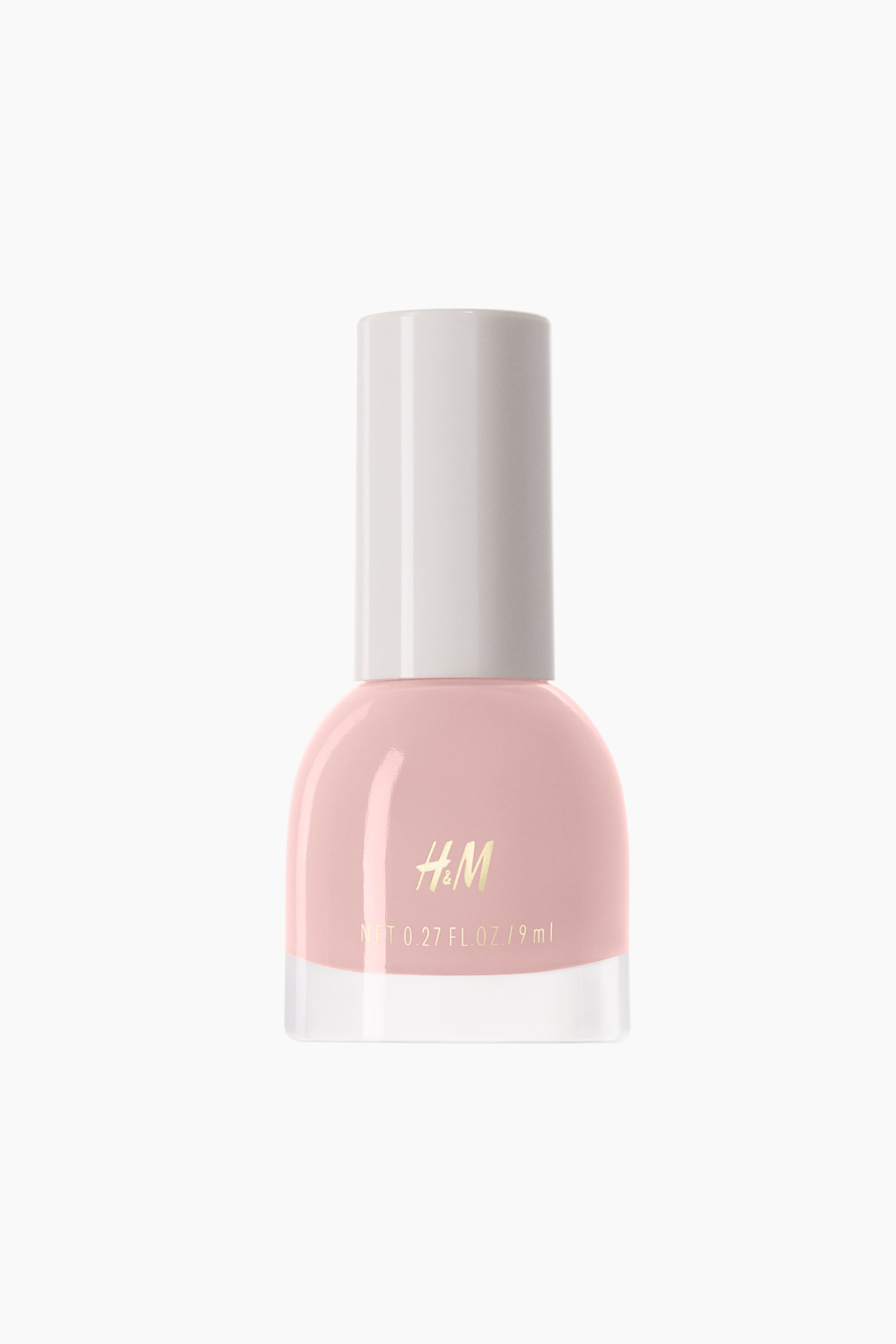 View larger image: Nail polish is shown in a front-facing view, showcasing a light pink shade in a rounded glass bottle with a thick, clear base. The bottle features gold-toned branding text on the front and is topped with a tall, cylindrical white cap.