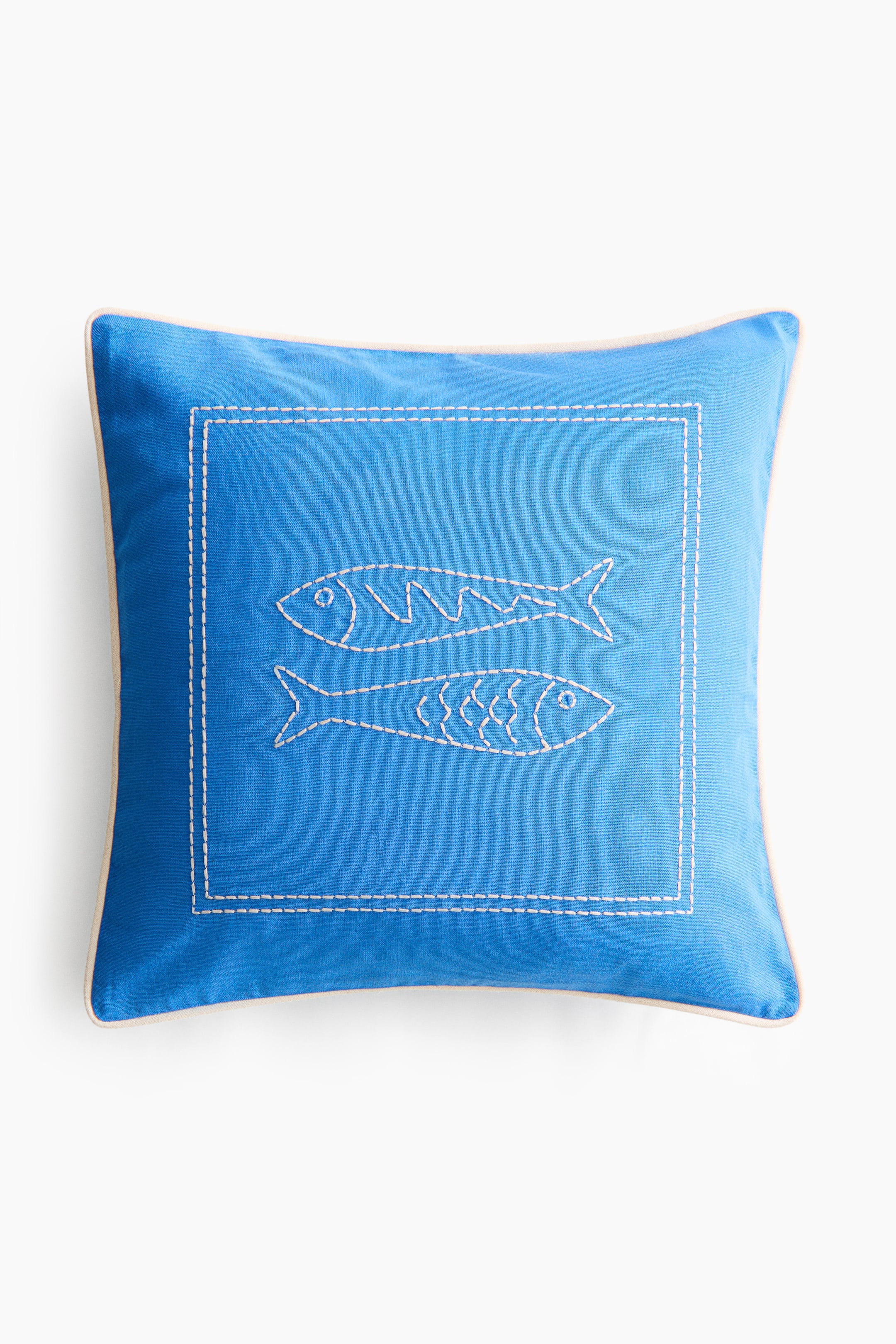 View larger image: Pillow, FRONT, is a square, vibrant blue cushion. It features light-coloured piping along its edges and a white embroidered dashed-line square border on its front surface, within which two white embroidered fish figures appear, one with zigzag body lines and the other with scale-like patterns.
