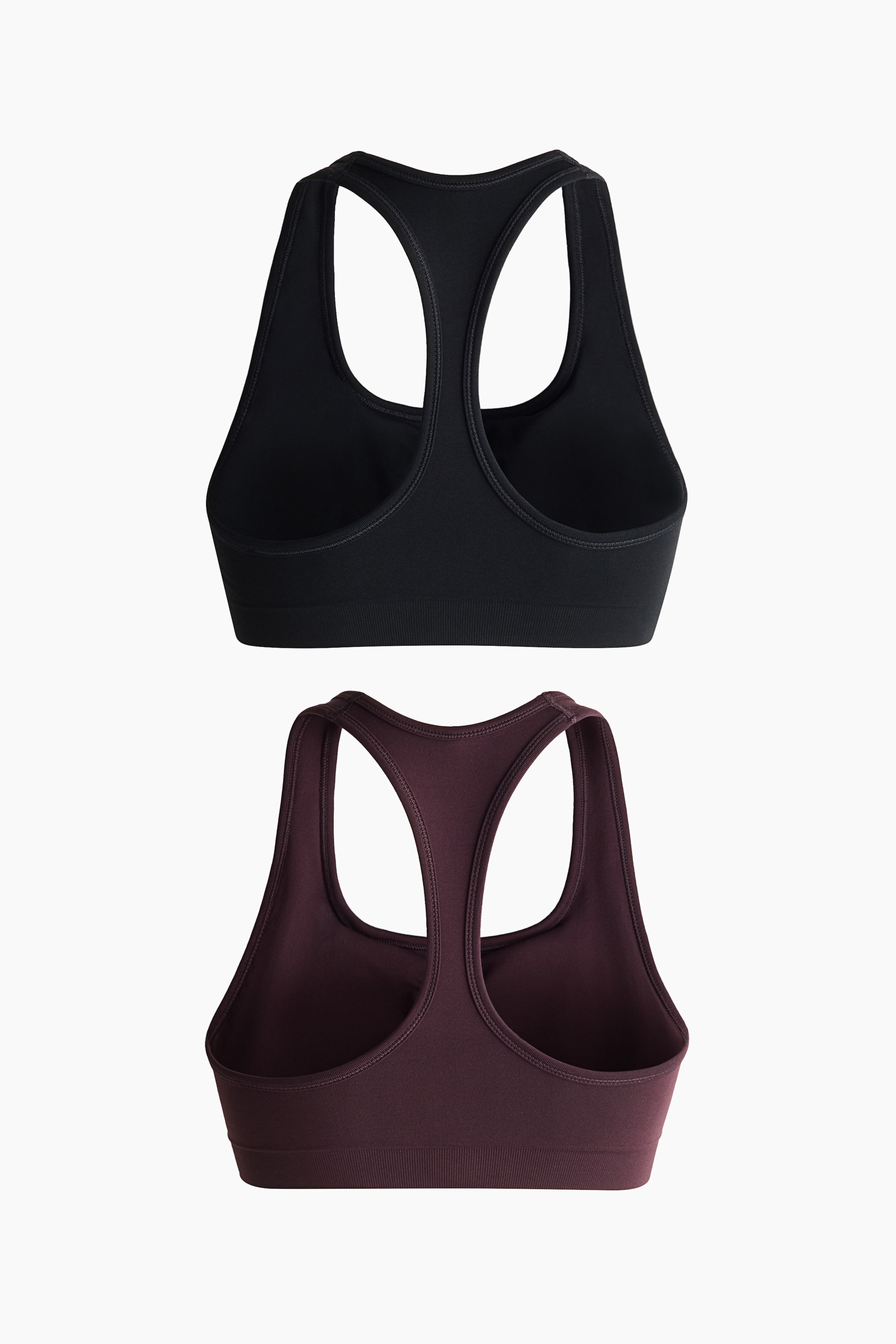 Visualizza l'immagine ingrandita: Due reggiseni sportivi senza cuciture sono mostrati dal retro. Il reggiseno nero e quello marrone rossiccio scuro presentano entrambi un design a schiena incrociata e una fascia inferiore a coste.