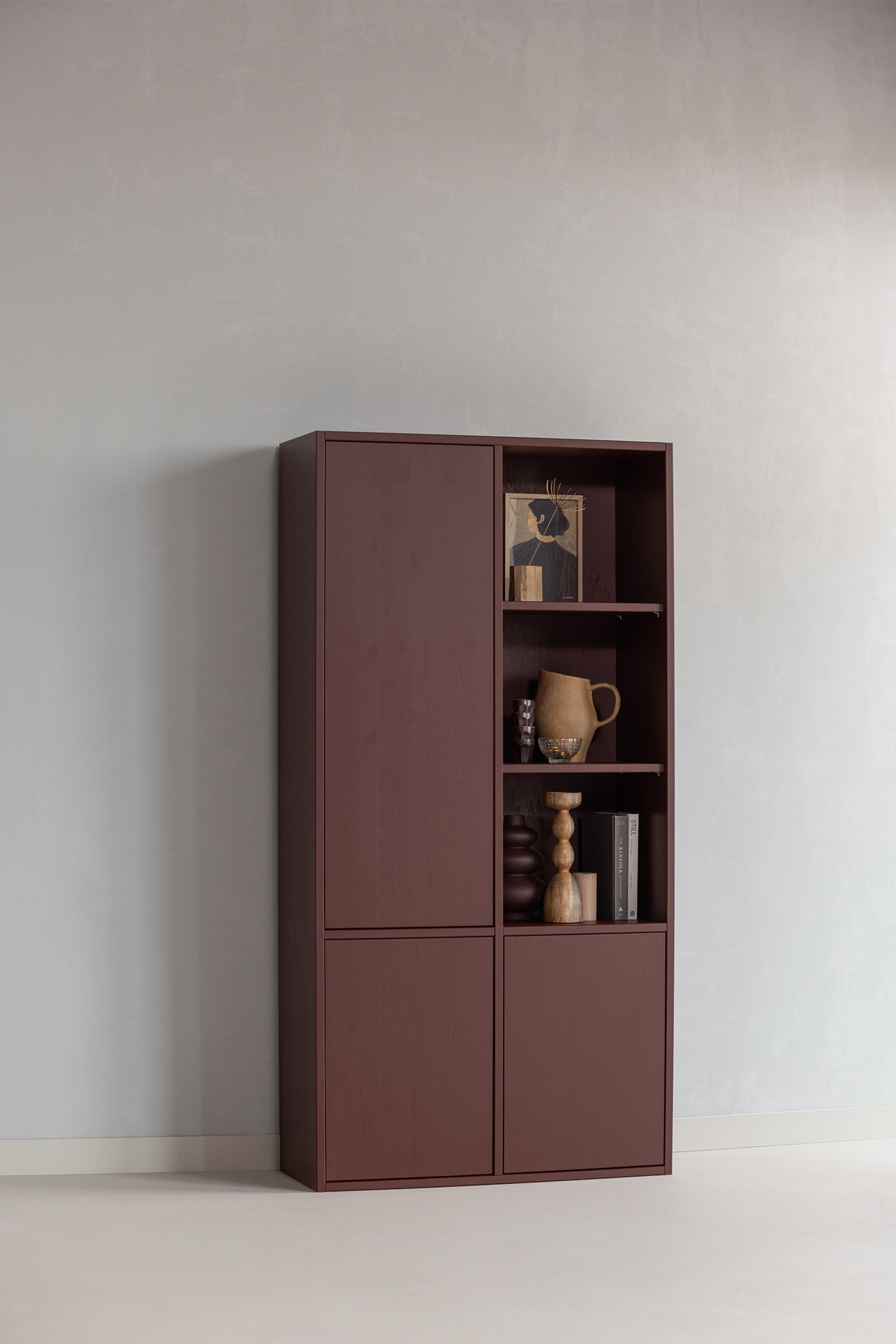 Größeres Bild anzeigen: Ein tief kastanienbrauner Schrank- und Regalblock steht nach vorne gerichtet, mit einem hohen, geschlossenen Schrank auf der linken Seite. Auf der rechten Seite befinden sich zwei offene Regale über zwei kleineren, geschlossenen Schränken, wobei die offenen Regale verschiedene dekorative Objekte präsentieren.