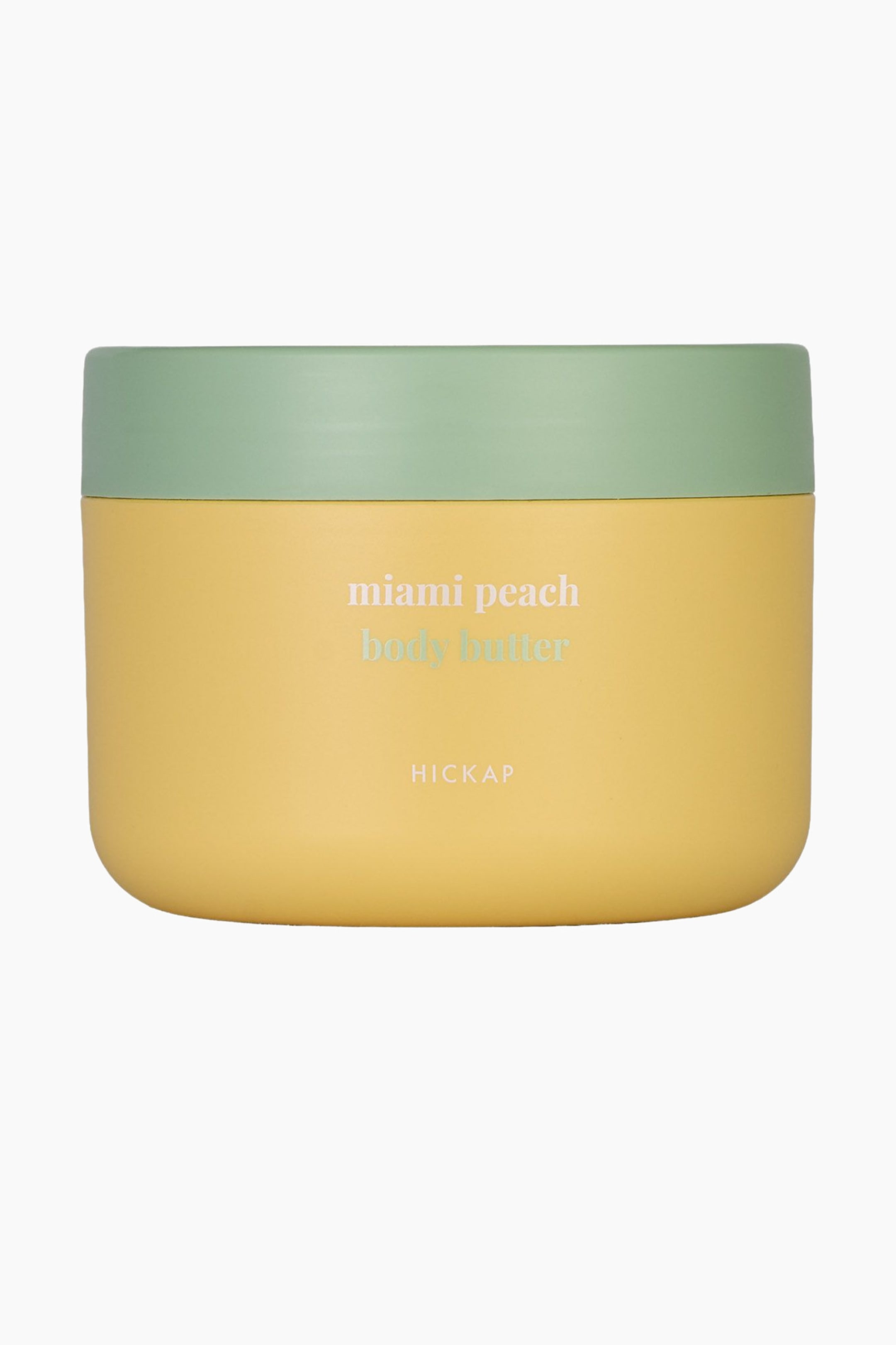 Se større billede: En rektangulær kropssmørkrukke med afrundede hjørner vender direkte fremad. Den har en gul bund og et lysegrønt låg, med teksten "miami peach body butter" og "HICKAP" på forsiden.