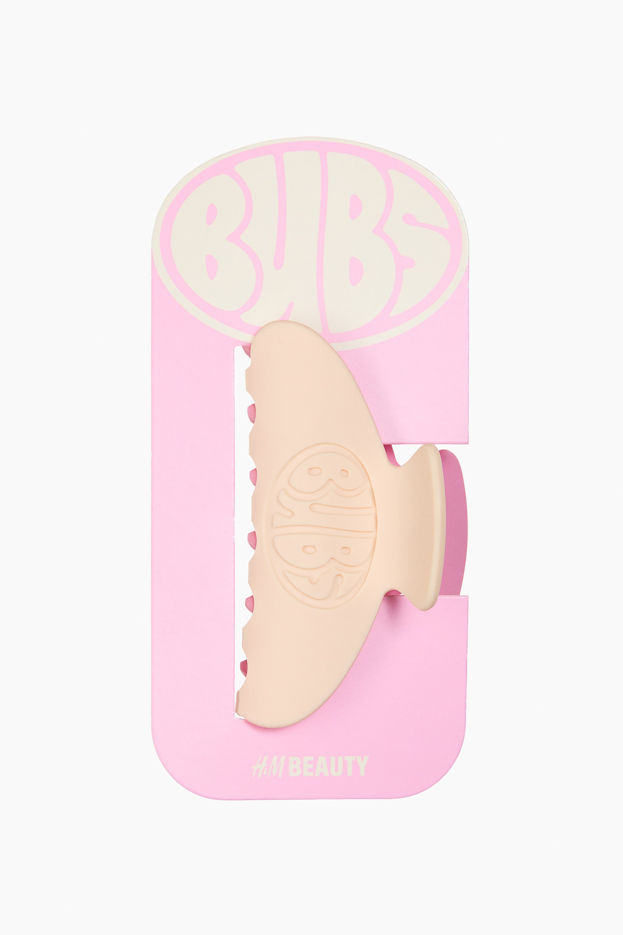 Agrandir l'image: Une pince à cheveux en plastique présente son devant, coloré dans une teinte pêche-beige clair et arborant un logo Bubs en relief sur son côté visible.