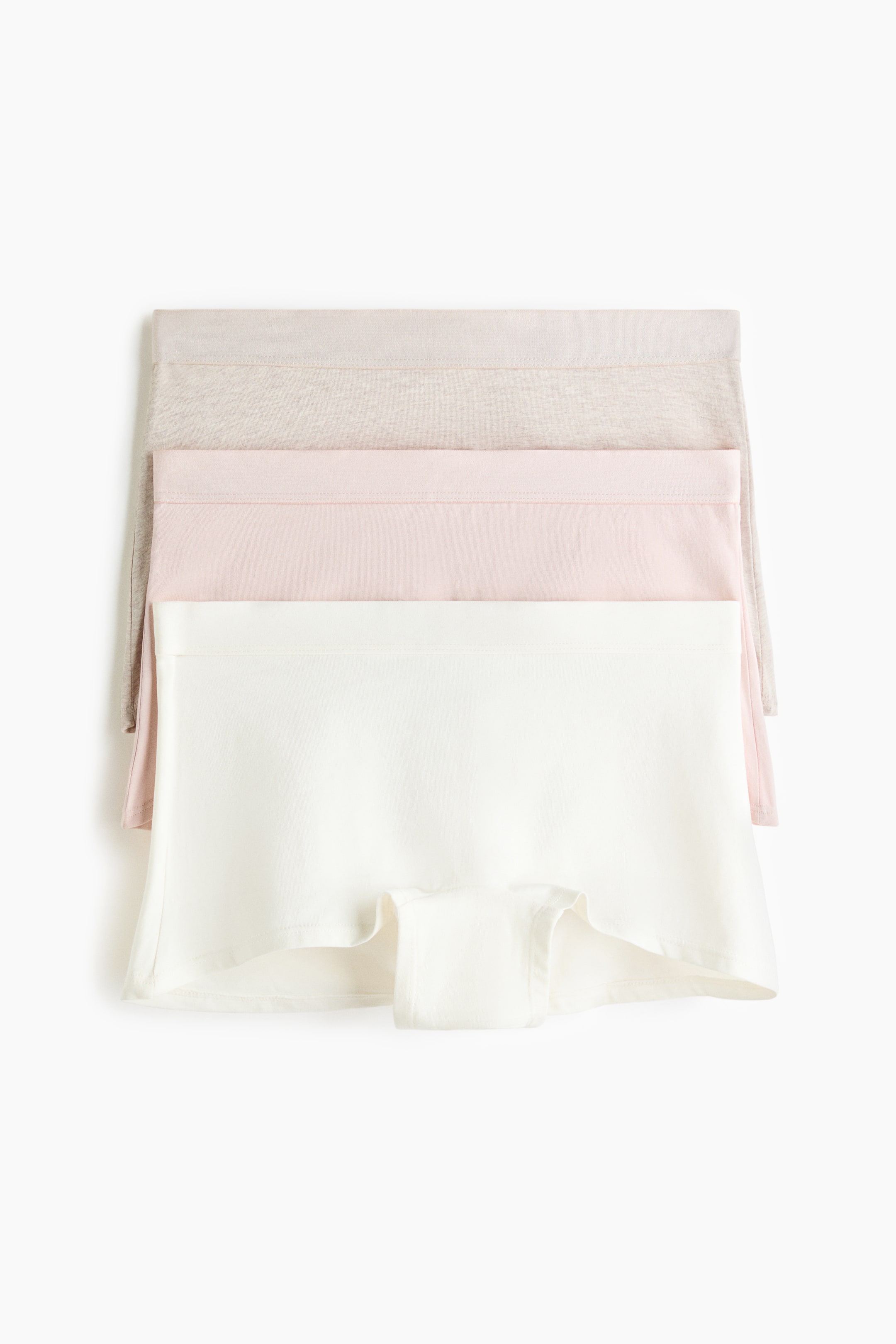 Agrandir l'image: Des boxers en jersey de coton sont empilés, présentant une vue de face de trois paires. La paire la plus en avant est blanc cassé, avec une taille mi-haute et un gousset doublé, tandis que les paires rose clair et gris clair sont partiellement visibles en dessous.