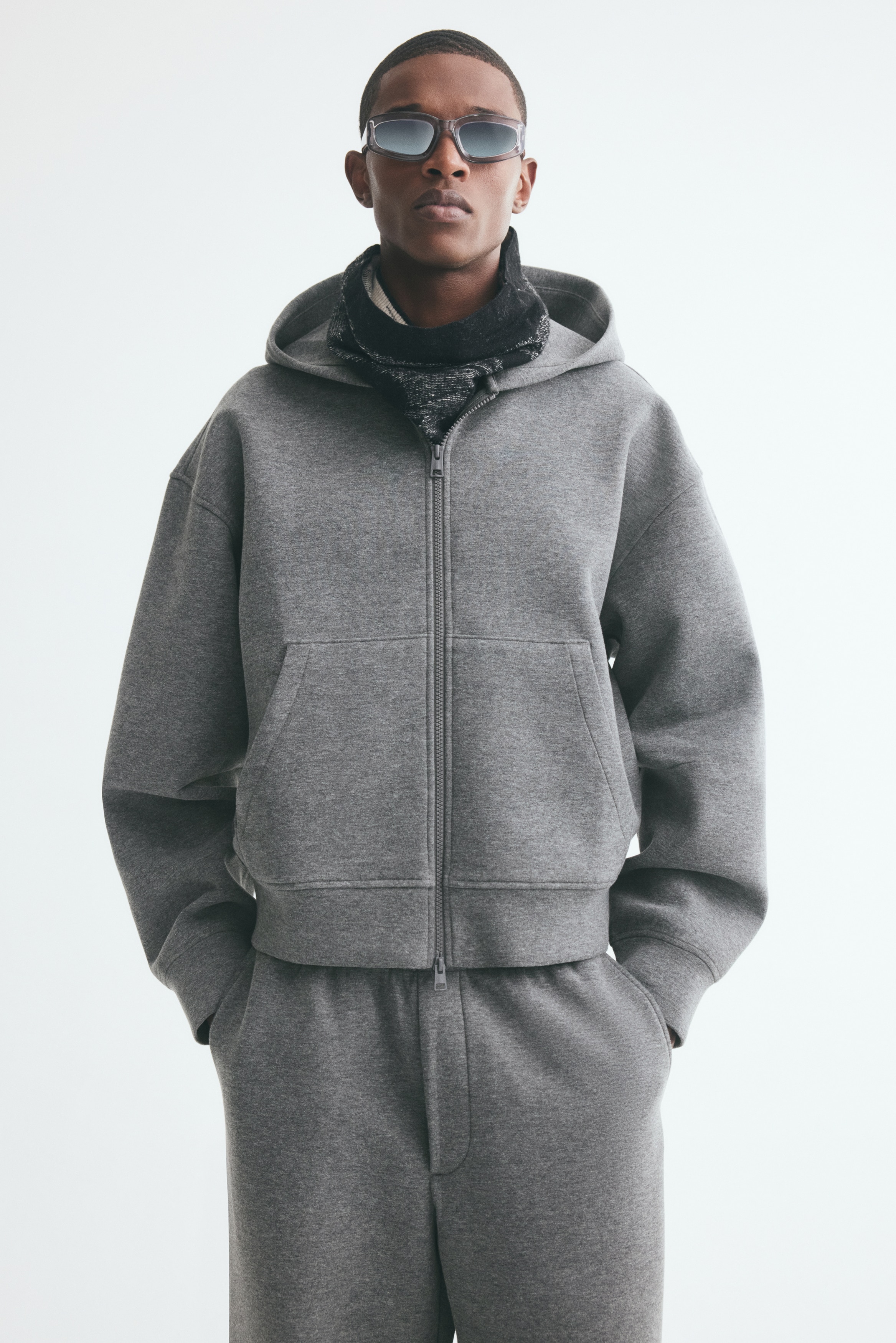 Má»t chiáº¿c Ã¡o hoodie mÃ u xÃ¡m cÃ³ khÃ³a kÃ©o Äang ÄÆ°á»£c chá»¥p tá»« phÃ­a trÆ°á»c, thá» hiá»n phom dÃ¡ng thoáº£i mÃ¡i vá»i pháº§n vai xuÃ´i vÃ  mÅ© khÃ´ng cÃ³ dÃ¢y rÃºt. Ão hoodie cÃ³ khÃ³a kÃ©o hai chiá»u cháº¡y dÃ i toÃ n thÃ¢n, tÃºi kangaroo chia ÄÃ´i vÃ  bo tay Ã¡o cÃ¹ng lai Ã¡o gÃ¢n.