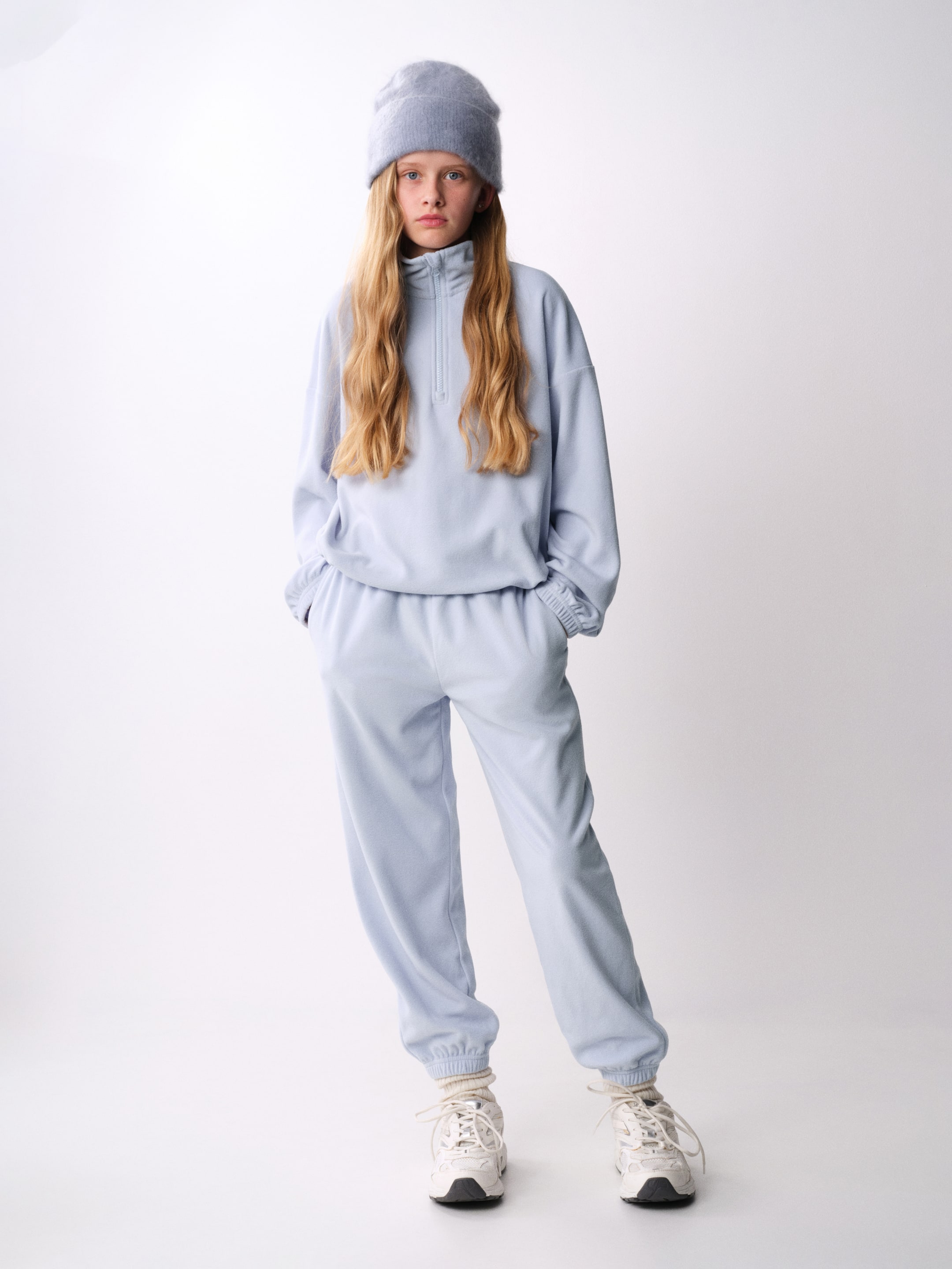 Grösseres Bild ansehen: Hellblaue Fleece-Sport-Jogginghose in Vorderansicht, mit Regular Fit, gesmoktem Elastikbund, dezenten Seitentaschen und verdeckten Elastikeinsätzen an den Säumen.