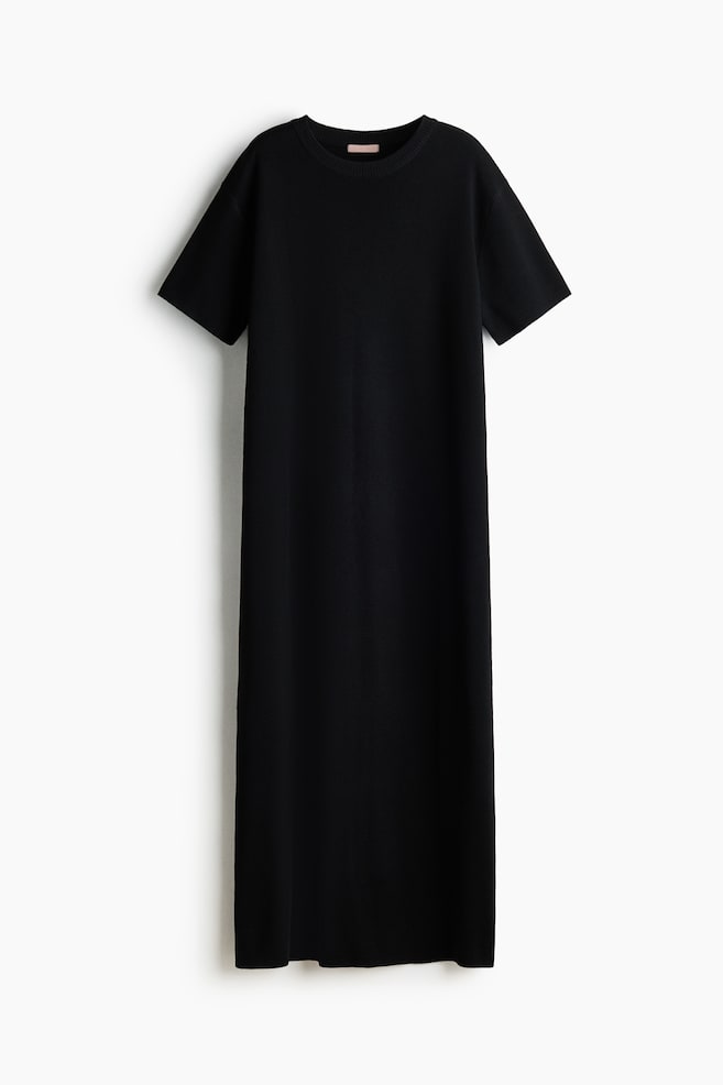 Ein schwarzes Strick-Maxikleid ist von vorne zu sehen, mit einem Rundhalsausschnitt mit geripptem Besatz und kurzen Ärmeln. Das Kleid präsentiert eine gerade, entspannte Silhouette. - 1