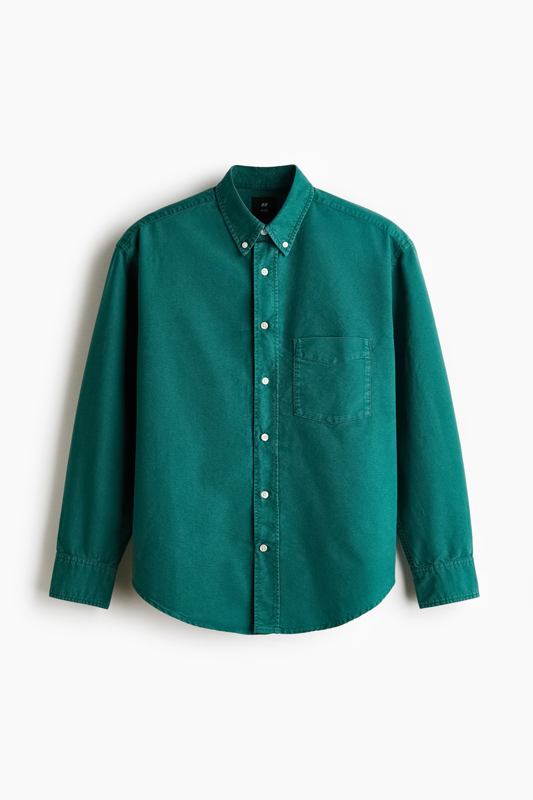 View larger image: A green shirt is showcased front-facing, featuring a button-down collar, a classic button placket, and a single open chest pocket. It displays long sleeves with buttoned cuffs and a gently rounded hem, indicating a relaxed fit.