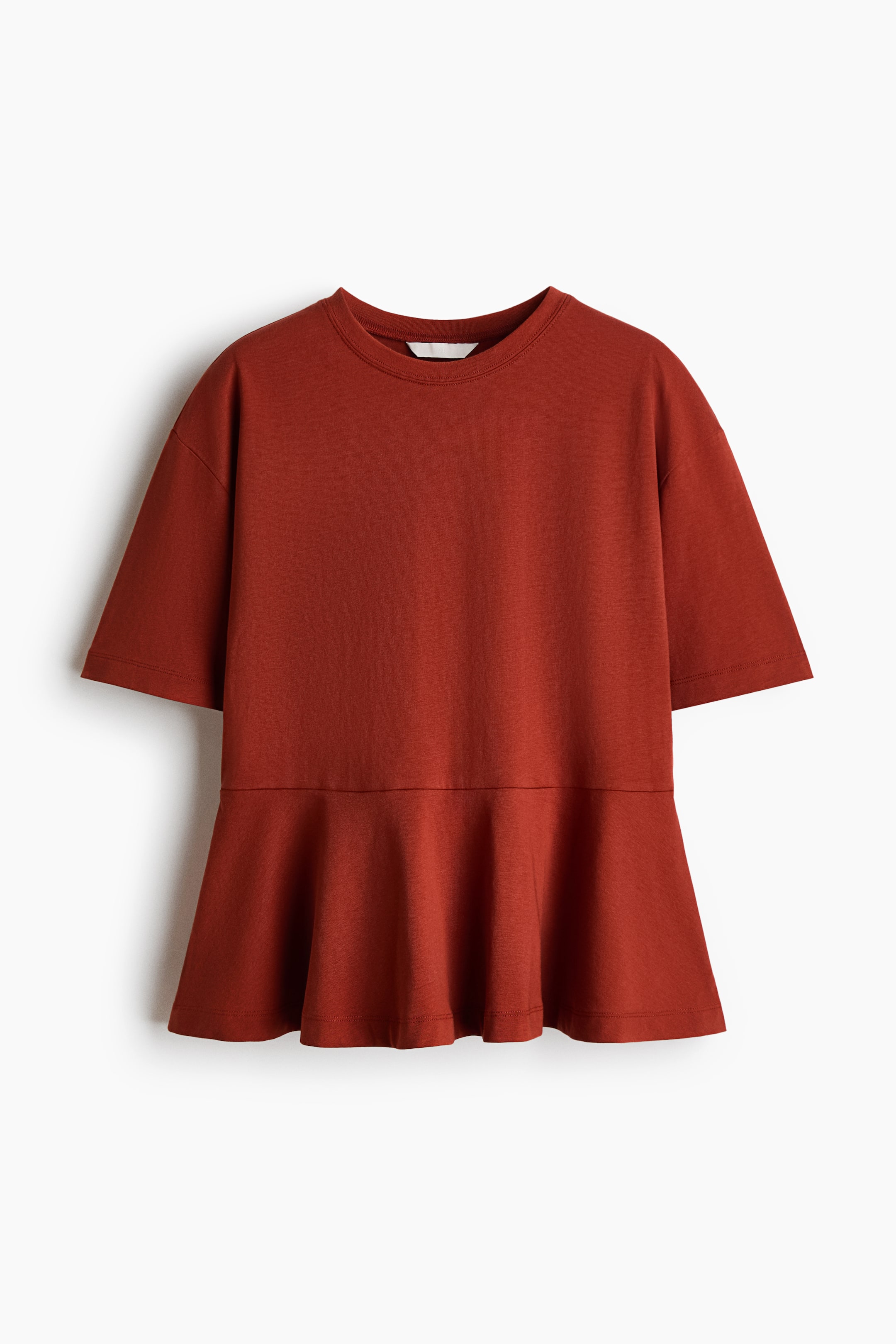 View larger image: A rust-coloured peplum top is shown from the front, featuring a round neckline, short sleeves with dropped shoulders, and a flared peplum hem.