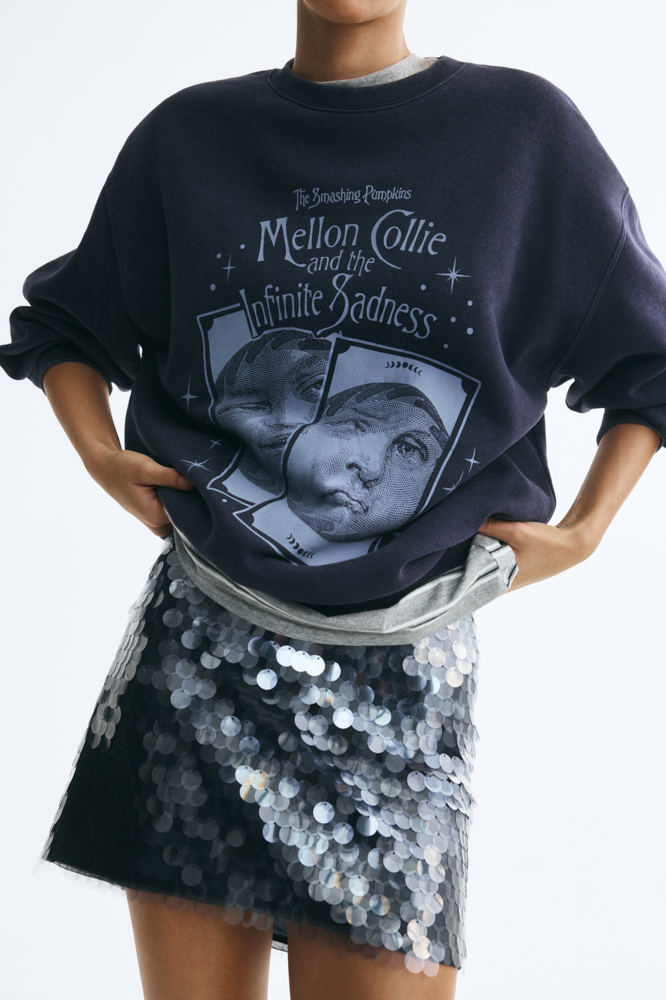 Má»t chiáº¿c Ã¡o sweatshirt mÃ u xanh navy Äáº­m, dÃ¡ng oversized, nhÃ¬n chÃ­nh diá»n, Äang hiá»n thá» há»a tiáº¿t in Äá» há»a mÃ u xanh nháº¡t cá»§a artwork 'The Smashing Pumpkins Mellon Collie and the Infinite Sadness' á» ngá»±c. Chiáº¿c Ã¡o sweatshirt cÃ³ cá» trÃ²n bo gÃ¢n, vai rá»t vÃ  tay dÃ i vá»i bo tay gÃ¢n cÃ¹ng gáº¥u Ã¡o bo gÃ¢n.