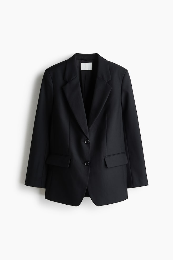 Ein schwarzer, einreihiger Blazer ist aus frontaler Perspektive zu sehen und verfügt über klassische fallende Revers, einen Zwei-Knopf-Verschluss vorne sowie strukturierte Taillenabnäher. Das Design umfasst zwei Pattentaschen vorne und lange, gerade Ãrmel, die eine taillierte Silhouette betonen. - 1