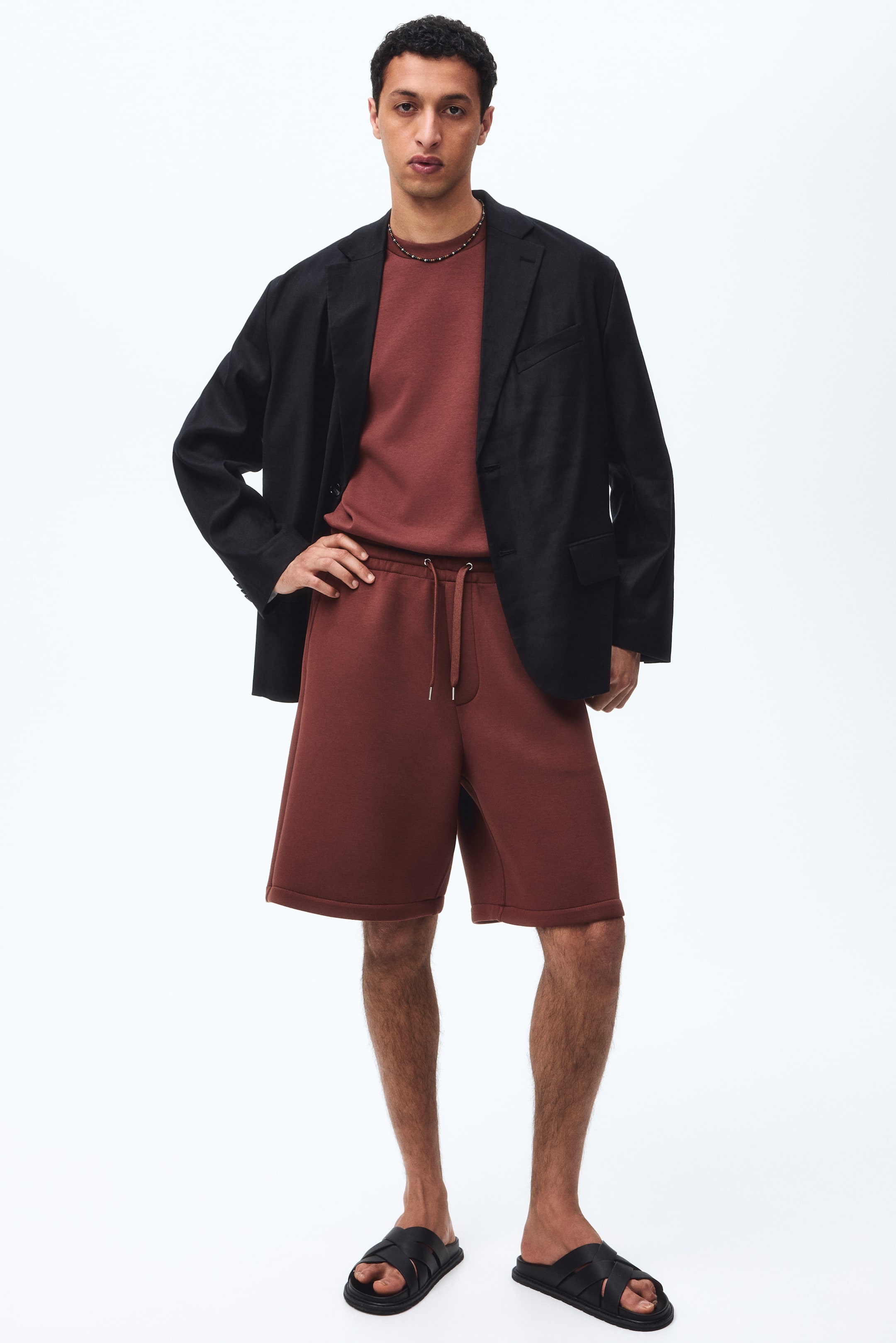 View larger image: Seluar pendek berwarna karat, dengan tali serut di pinggang dan poket sisi serong, sedang dipakai oleh model. Seluar pendek ini menawarkan potongan santai dan kasual serta digayakan bersama baju padanan dan blazer hitam.