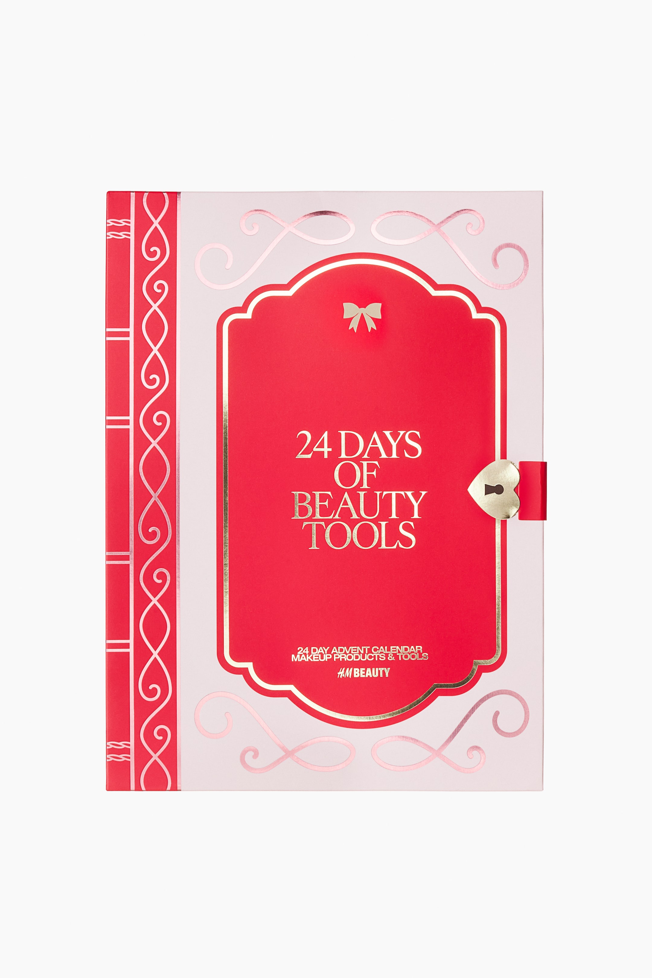 Zobraziť väčší obrázok: 24-dňový beauty adventný kalendár je zobrazený spredu a má tvar svetloružovej škatule v podobe knihy. Jeho obal má červenú hranu pripomínajúcu chrbát knihy s ružovozlatým ornamentálnym zdobením naľavo a centrálny červený panel s pozláteným orámovaním. Na tomto paneli je v zlatom písme uvedené „24 DAYS OF BEAUTY TOOLS“ a zdobí ho malá zlatá mašľa hore a zámok v tvare srdca v zlatej farbe s červeným pútkom na pravej strane.