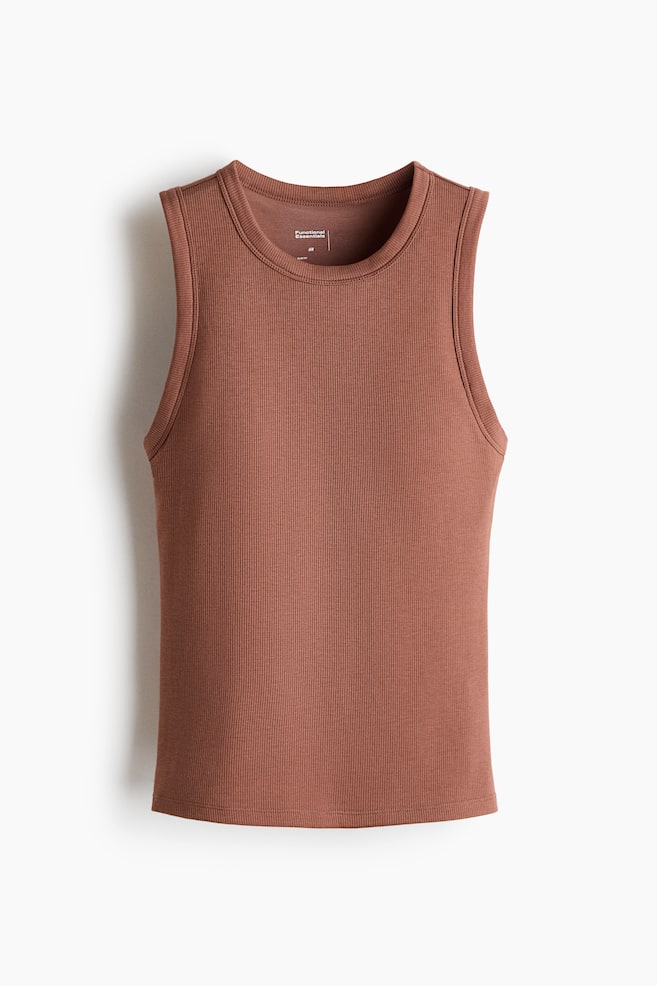 Se presenta una camiseta sin mangas acanalada de color marrón vista de frente. Cuenta con un cuello redondo, sisas acabadas y un dobladillo recto. - 1