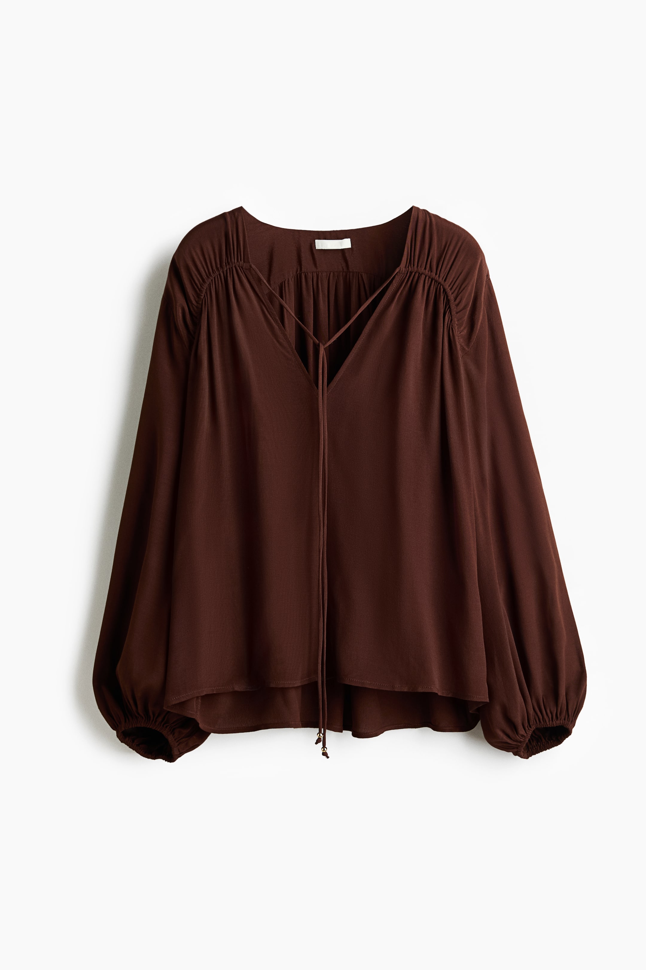 View larger image: A dark brown blouse is showcased in FRONT, featuring a square neckline with a V-cut opening, criss-cross tie-front strings, gathered shoulders, long balloon sleeves with elasticized cuffs, and a relaxed, flowing silhouette.