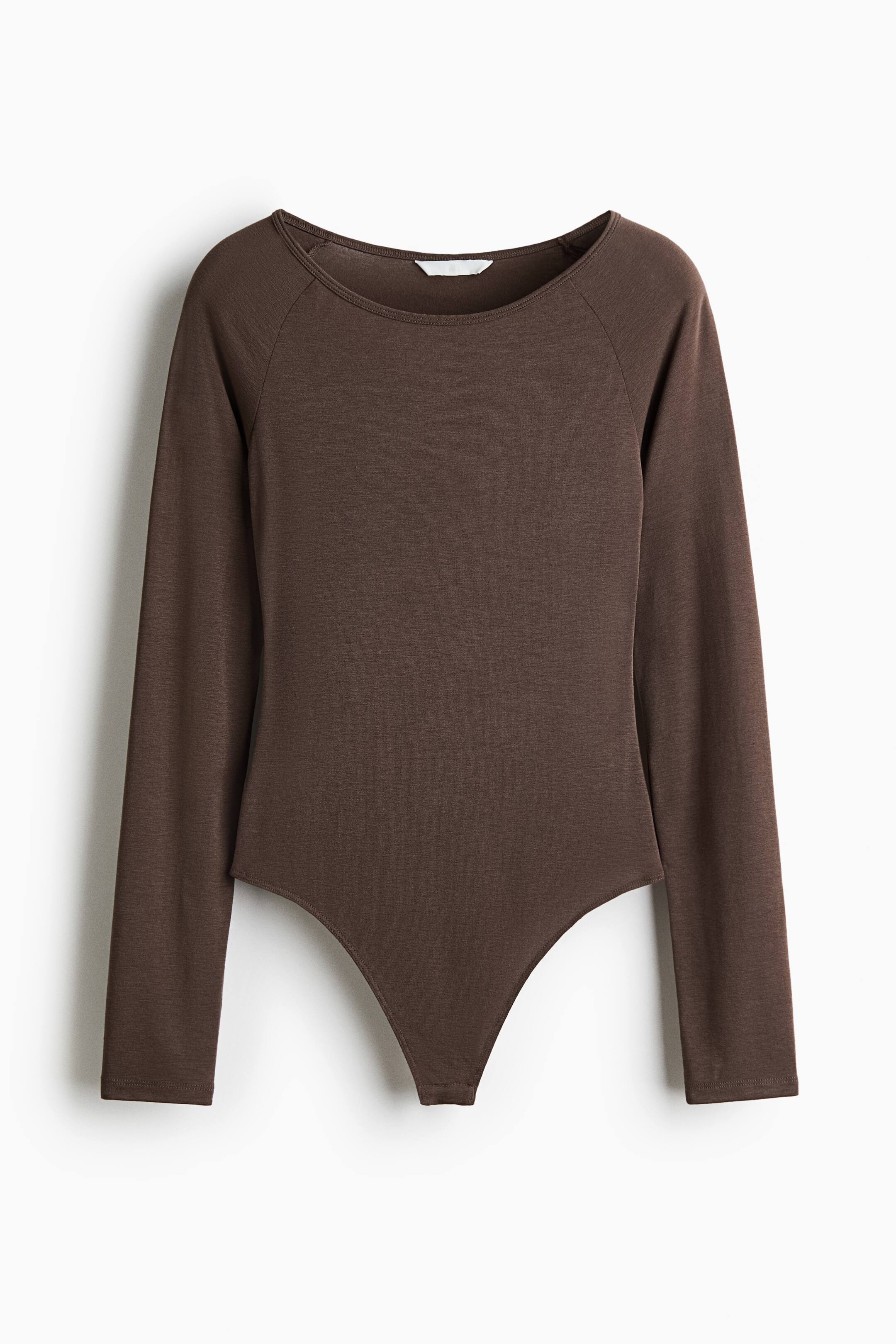 Größeres Bild ansehen: Ein dunkelbrauner Langarm-Body ist von vorne zu sehen und verfügt über einen weiten U-Ausschnitt sowie Raglanärmel. Das Kleidungsstück zeigt eine weiche, fein gestrickte Struktur und einen hoch geschnittenen Beinausschnitt.