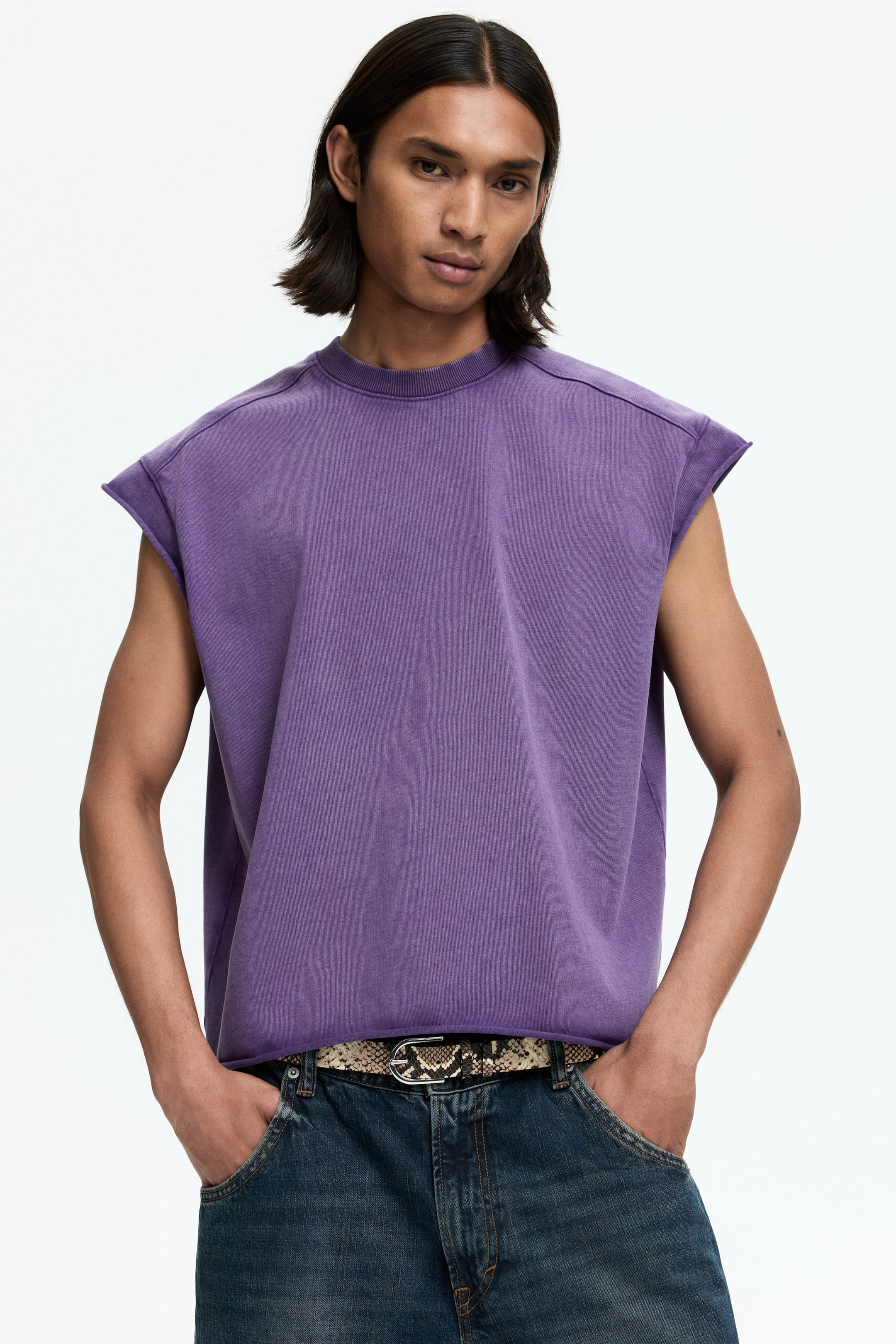 View larger image: The purple sleeveless top showcases a subtle purple hue, a ribbed crew neck, highlighted shoulder seams, raw-edge armholes, and a cut-off bottom hem.