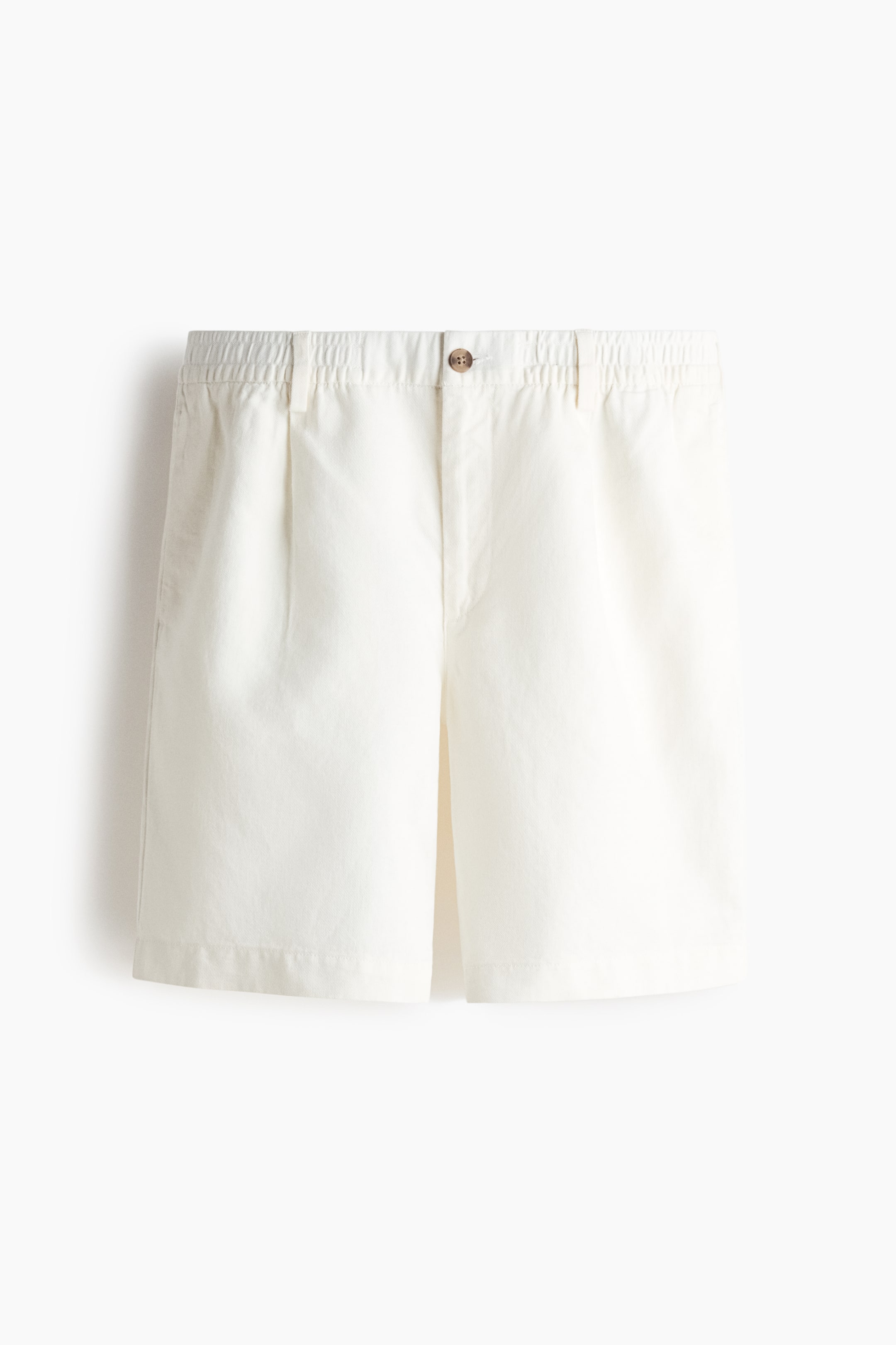 View larger image: White shorts showcase a front view, highlighting an elasticated back waistband, a flat front with belt loops, a single brown button closure, and two front pleats.