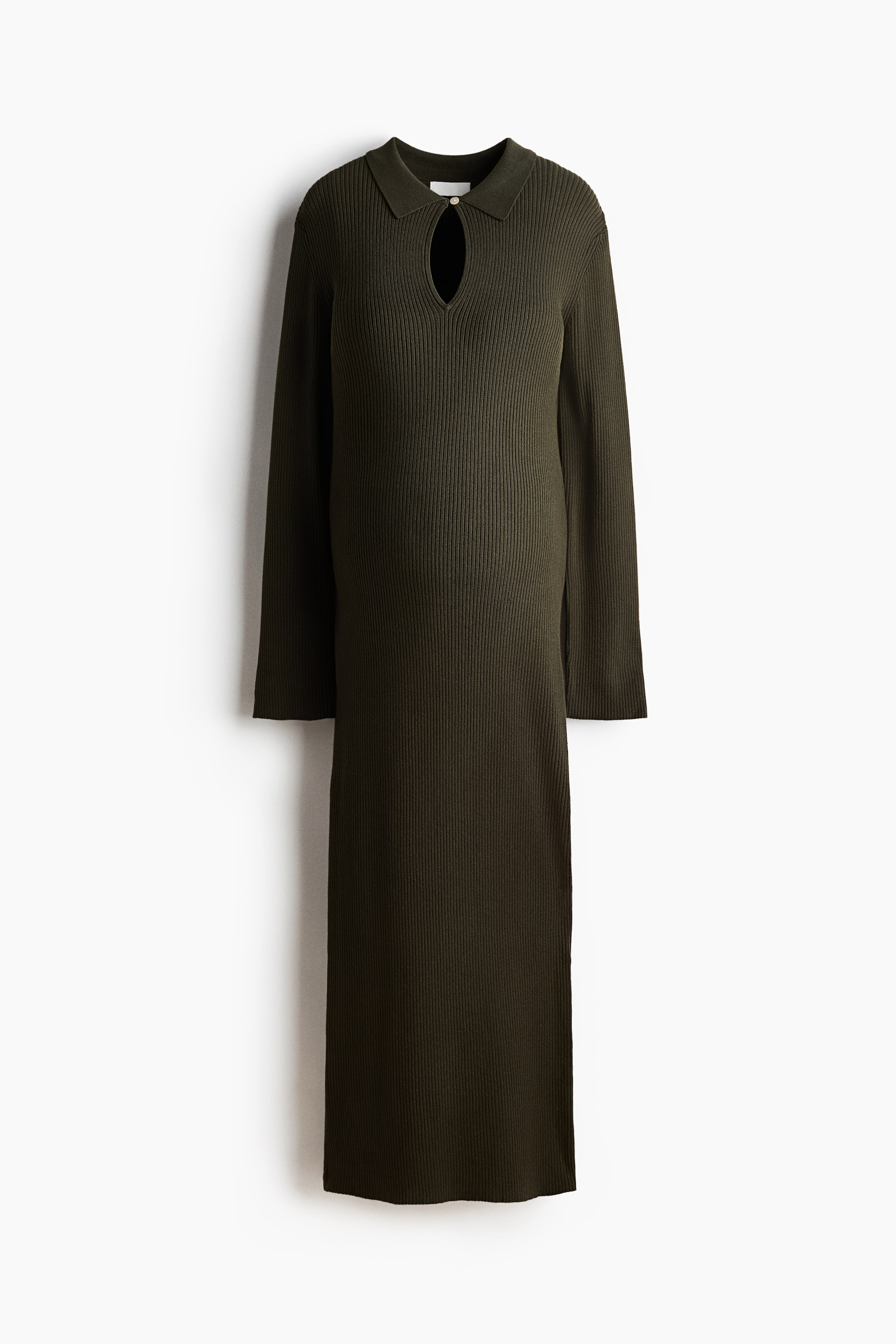 Ver imagen más grande: Un vestido de punto acanalado en color verde oscuro, con cuello polo y un corte de ojo de cerradura asegurado por un botón dorado, con mangas largas y longitud midi.